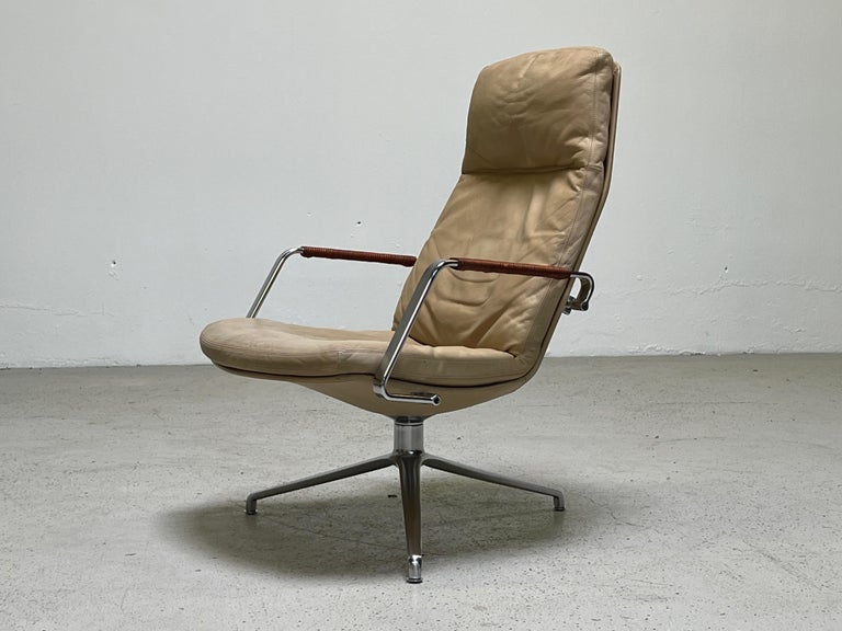 A swiveling FK 86 lounge chair designed by Preben Fabricius & Jørgen Kastholm. Original ivory leather with leather wrapped arms.