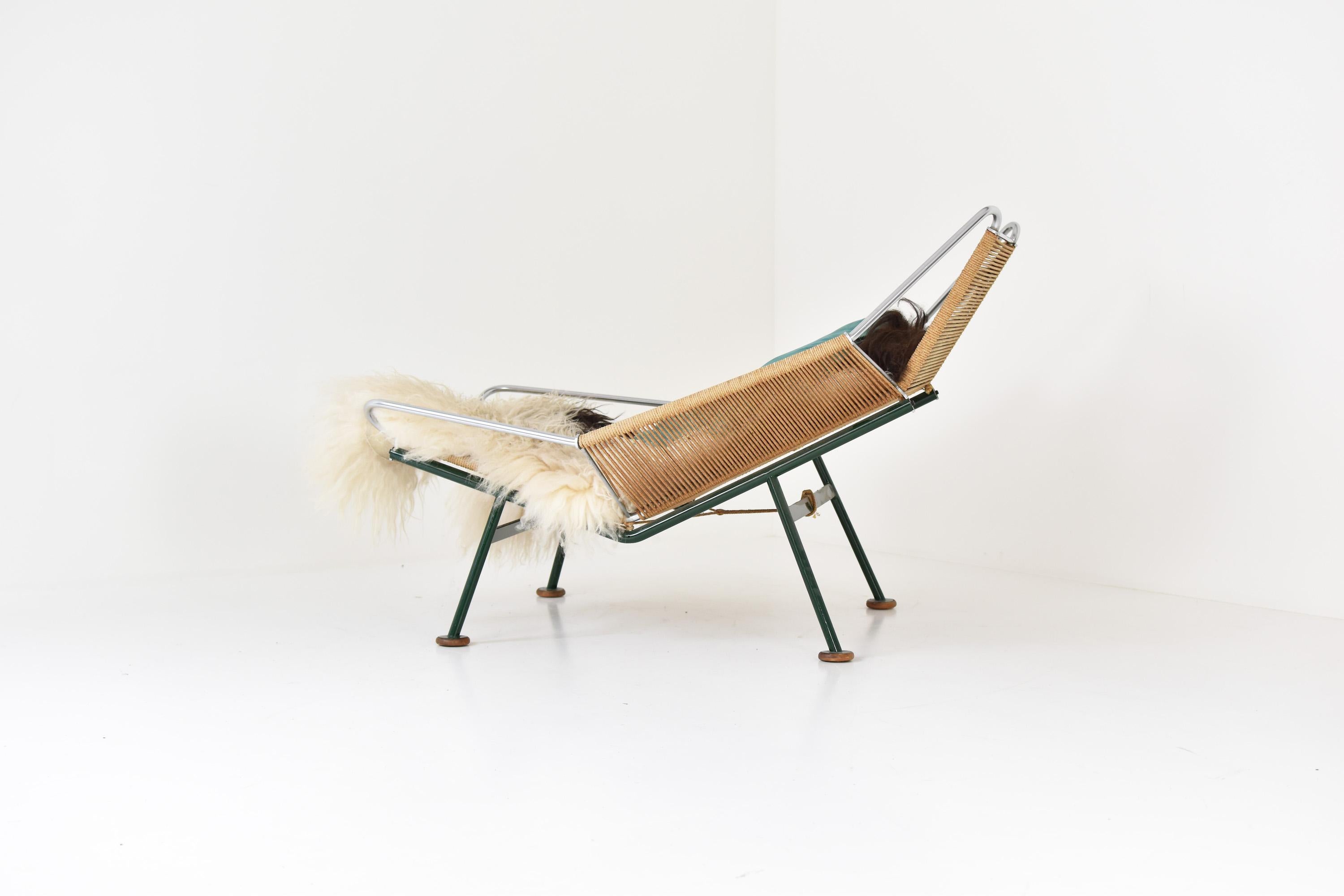 Iconic flag Halyard GE225 easy chair designed by Hans J. Wegner for Getama, Denmark 1950’s. This easy chair comes from the first edition series and has a dark green lacquered steel frame with wooden shoes. Original cushions and flag line (with