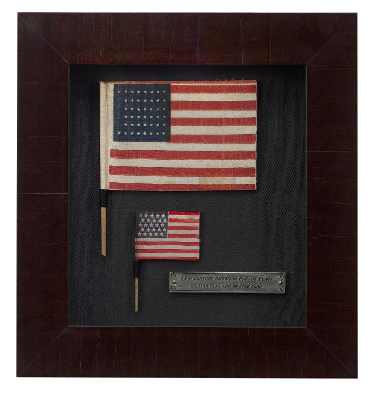 Presented is a unique celebration of early American parade flag wavers. This item includes two antique American parade flag wavers framed together, a 25-star American flag waver dating to 1836 and a 44-star American flag waver dating to 1891. Parade