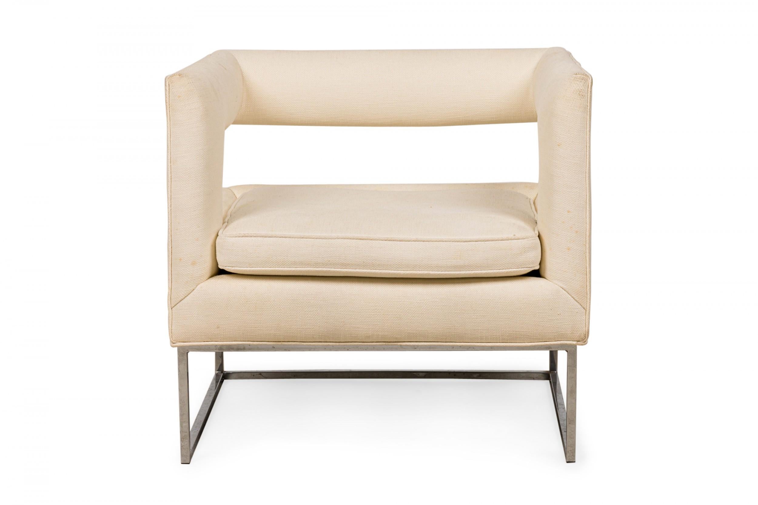 American Contemporary cube form lounge / armchair with an open back and beige fabric upholstery, resting on a square chrome tube base. (FLAIR)