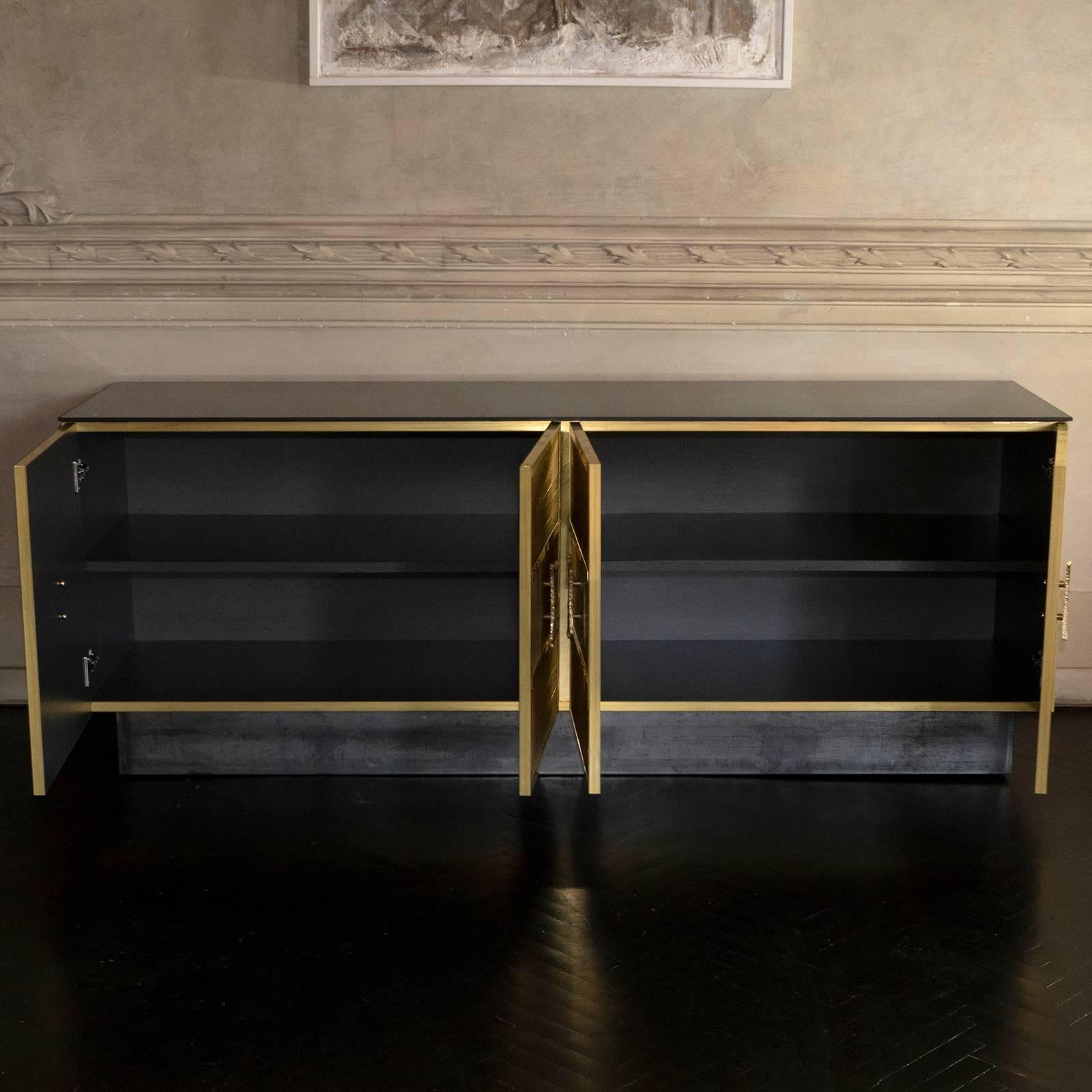 One of a kind four doors sideboard, covered with natural brass wire applied vertically and horizontally as to create a geometrical design, interior in grey laminate, top in black painted glass, natural raw steel base, natural brass details.
 