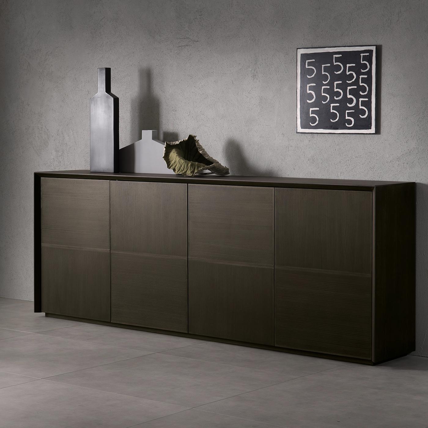 This elegant sideboard was designed by Giuliano Cappelletti and crafted of wood with the exterior veneered in ash and profiles in solid ash. Inside, the versatile storage space is separated by shelves in wood. The front panels create a geometric