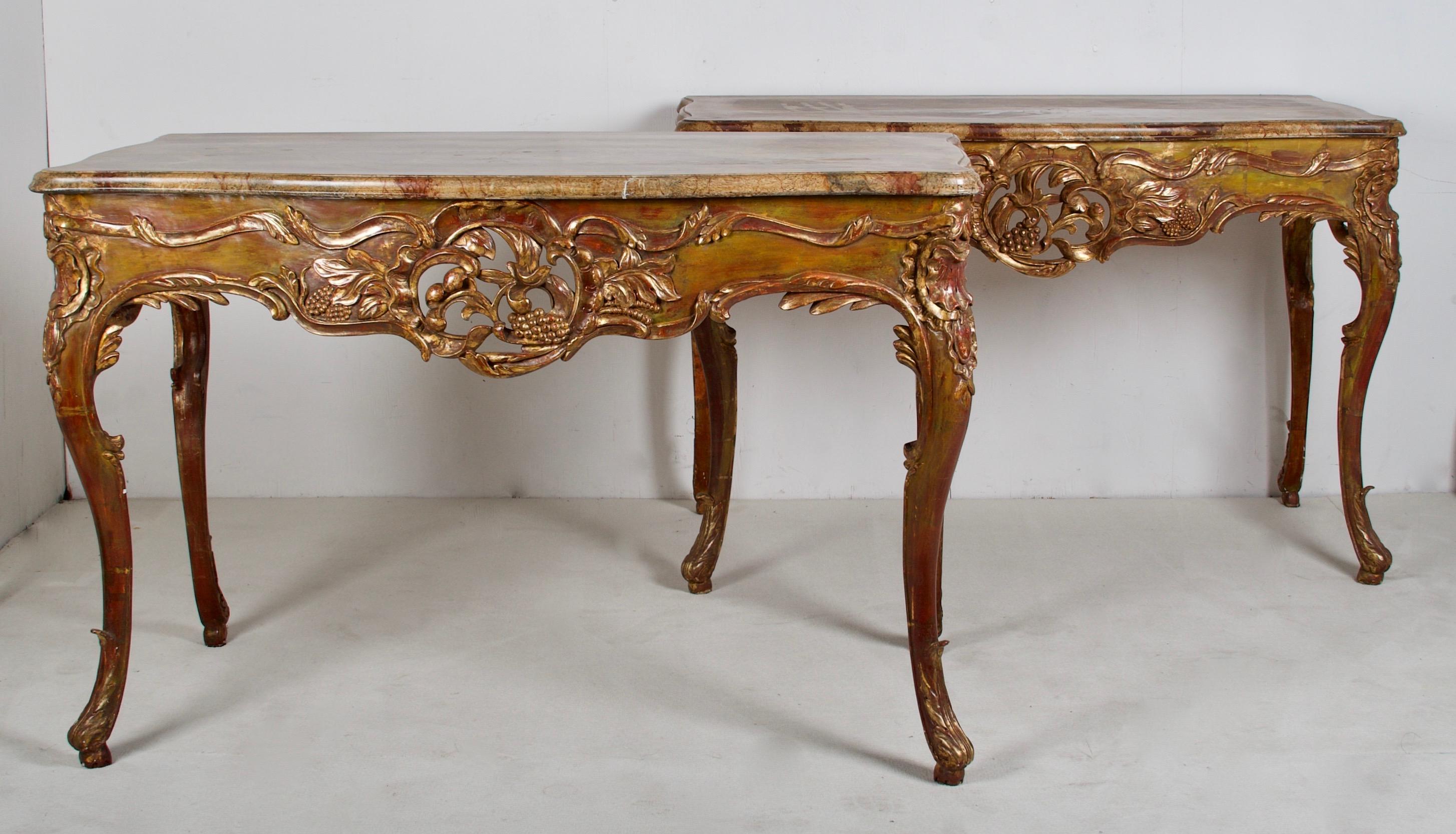 A playfull and flamboyant pair of painted and gilded, hand carved console tables, finished
with a nicely done faux marble top.