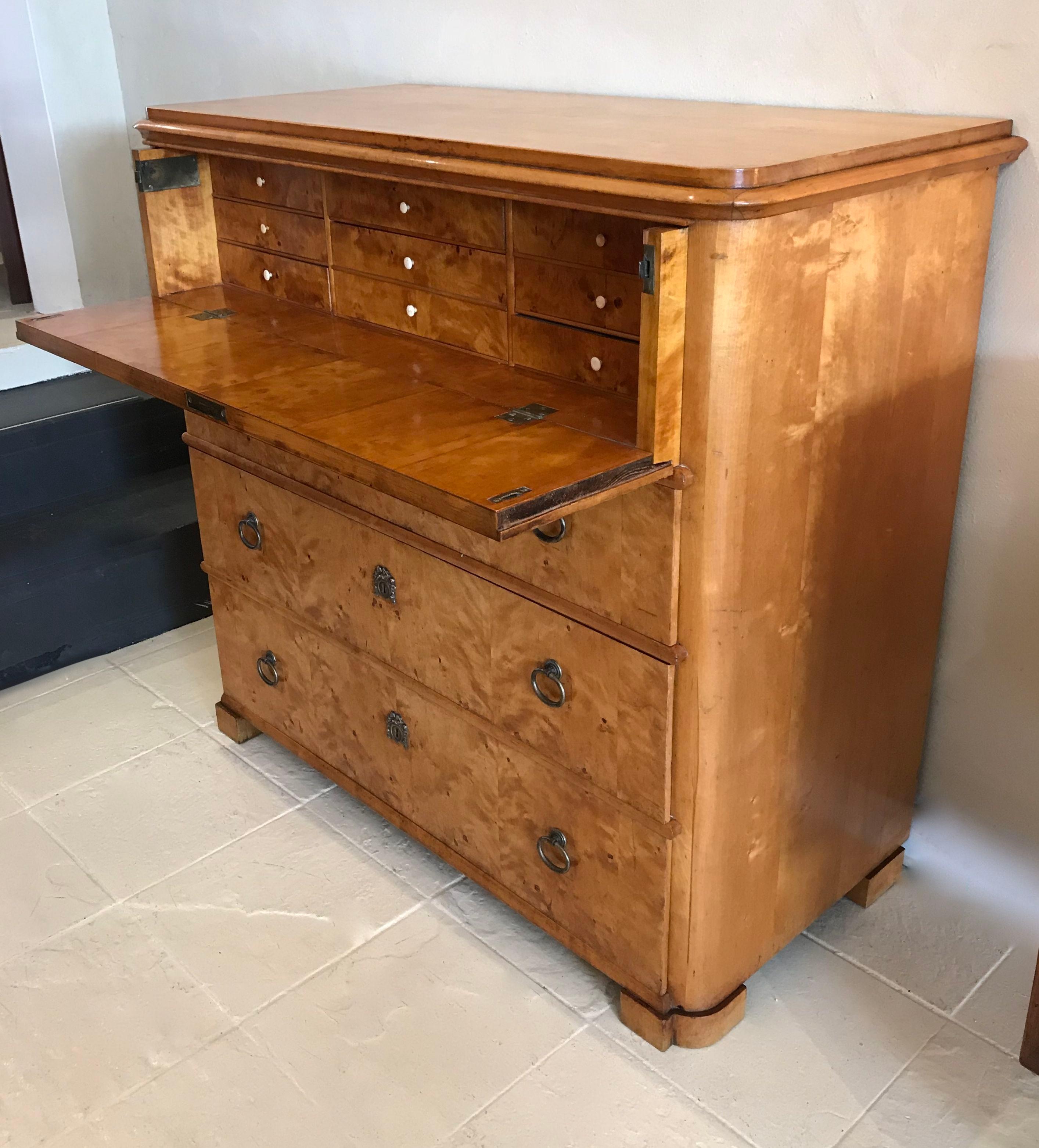 Flame birch Biedermeier secretaire chest with lovely small proportions. The top draw drops down to a writing area with several small fitted drawers to the interior. There are three generous sized drawers below the writing section.