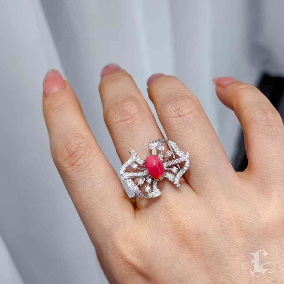 Dieses kunstvolle Jewell aus kostbaren Edelsteinen kann sowohl als Statement-Ring als auch als auffälliger Anhänger getragen werden. In ihrem Zentrum ruht eine 2,42 Karat große, tiefrosa Muschelperle mit sanftem Flammenmuster - ein satter und