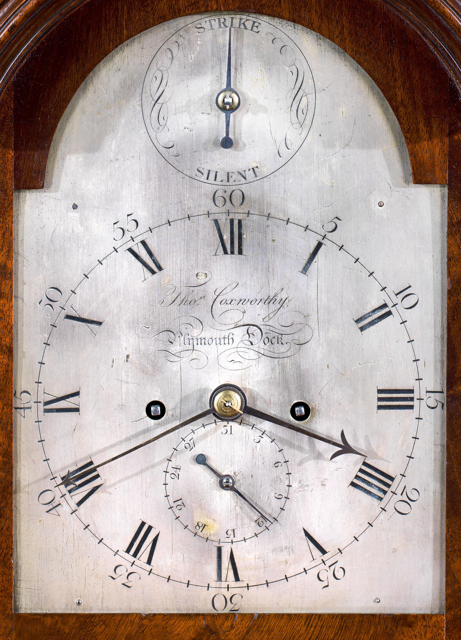A fine 18th century eight day bracket or table clock by Thomas Coxworthy, with a brass bound flame mahogany veneered case and silvered dial. The arched silvered dial has both Roman and Arabic numerals, which at its centre has the smaller calendar