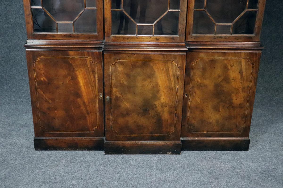 This is a gorgeous 1940s flame mahogany Baker breakfront that is only 14 inches deep! That's very, very shallow. The breakfront is a one piece cabinet and does not come apart and will need professional detailing which we will do for the lucky buyer.