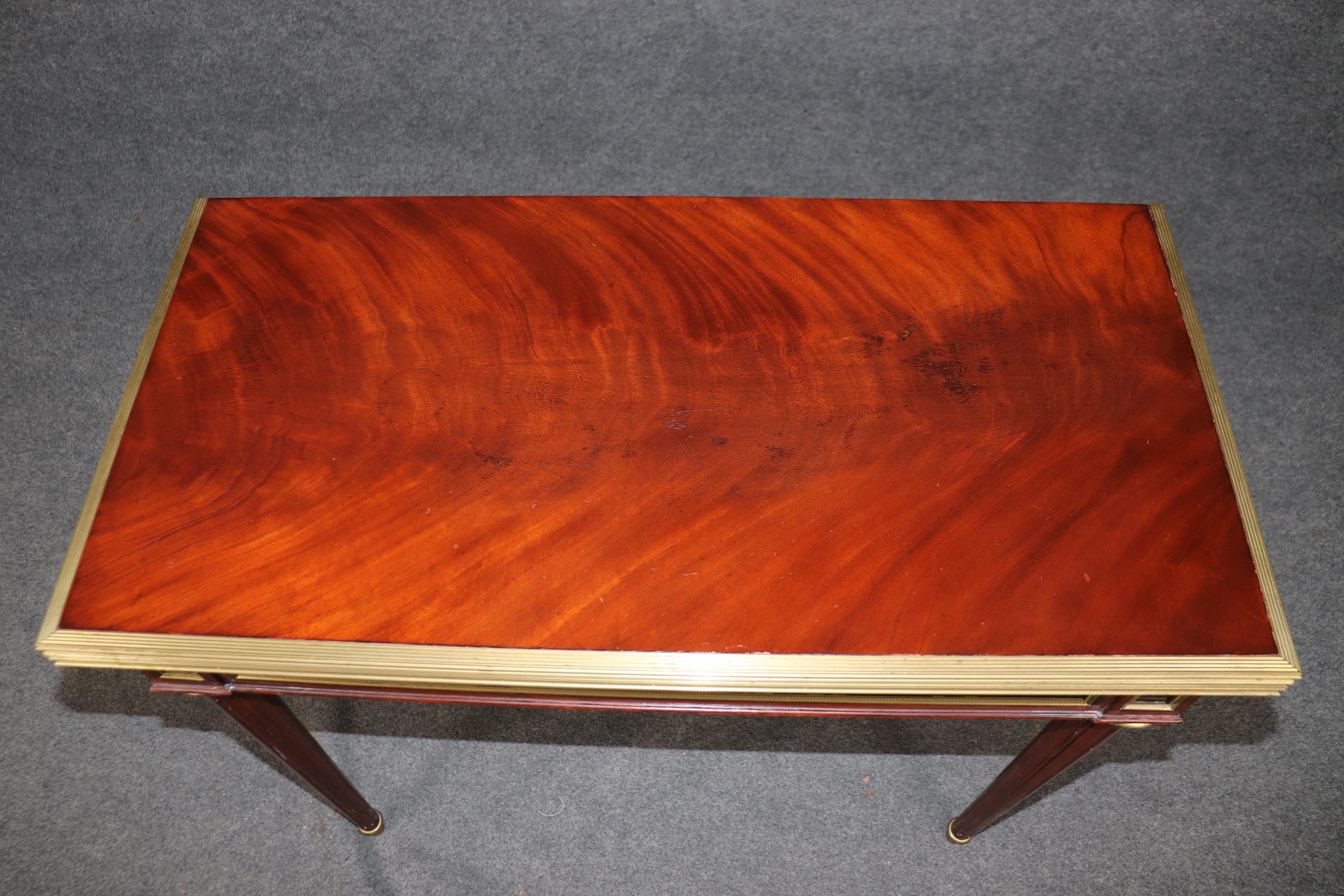 This an absolutely superbly crafted French Directoire style chess or checkers table. The top is absolutely gorgeous flame mahogany surrounded by brass trim and a gorgeous finish. The table is French-made and dates to the 1900-1910 era. The table is