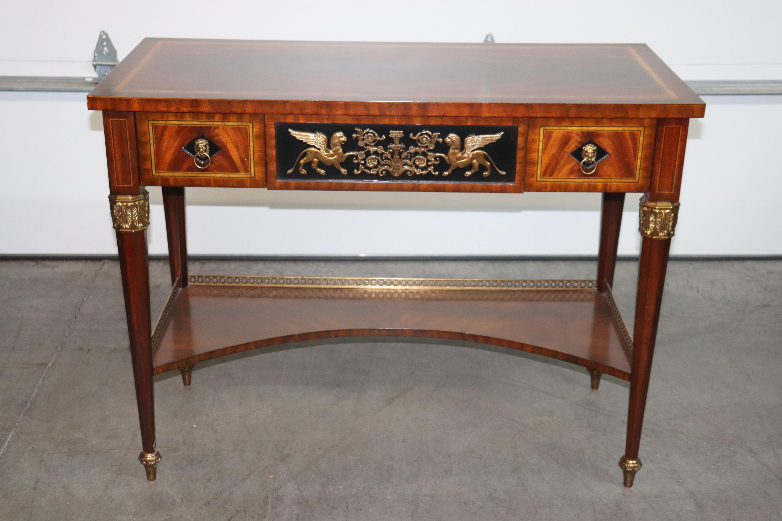 This is a stunning flame mahogany and bronze mounted console table in the French Empire style with winged griffins and beautiful bronze ormolu. The table is in good vintage condition with no major flaws or issues of any kind to mention. The table