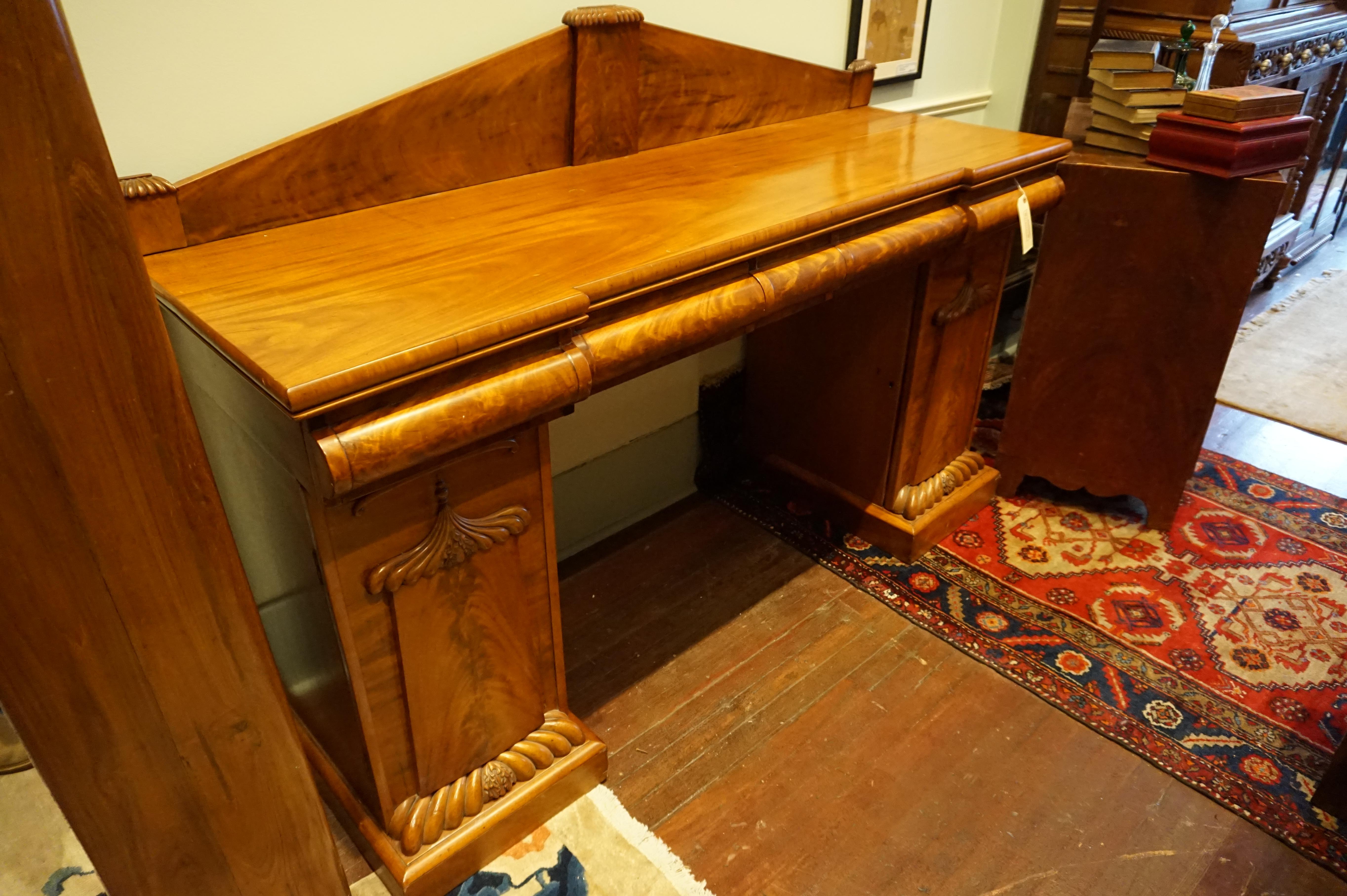 Scottish Flame mahogany sideboard.
Exquisite sideboard acquired from the estate of the Ex Commissioner General of New Foundland and Labrador, this flame mahogany buffet exudes elegance with gable ledge and hand carved doors echoing flaming grains.