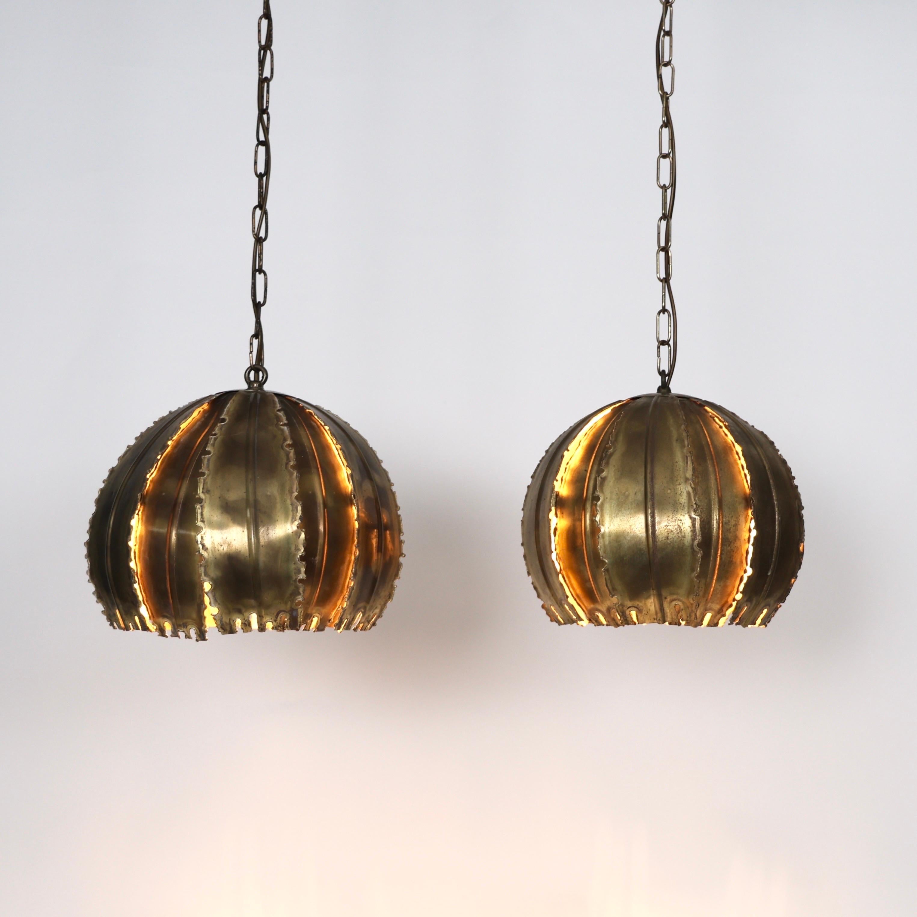 Set di lampade a sospensione in ottone brutalista disegnate da Svend Aage Holm Sørensen negli anni Sessanta. Un duo squisito.

* Set (2) di luci a sospensione in ottone con ardesia e corde sostenute da catene
* Designer: Svend Aage I. Holm