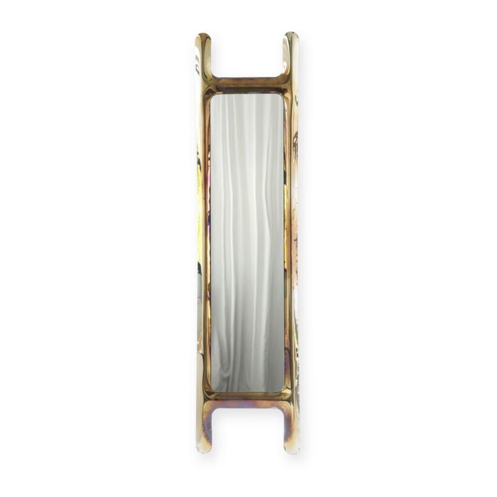 Specchio da parete scultoreo in oro drabescato fiammato di Zieta
Dimensioni: P 6 x L 46 x H 188 cm 
Materiale: Specchio, acciaio inox. 
Finitura: Termico colorato in oro fiammato. 
Disponibile anche nei colori: Oro fiammato, blu cosmico, acciaio