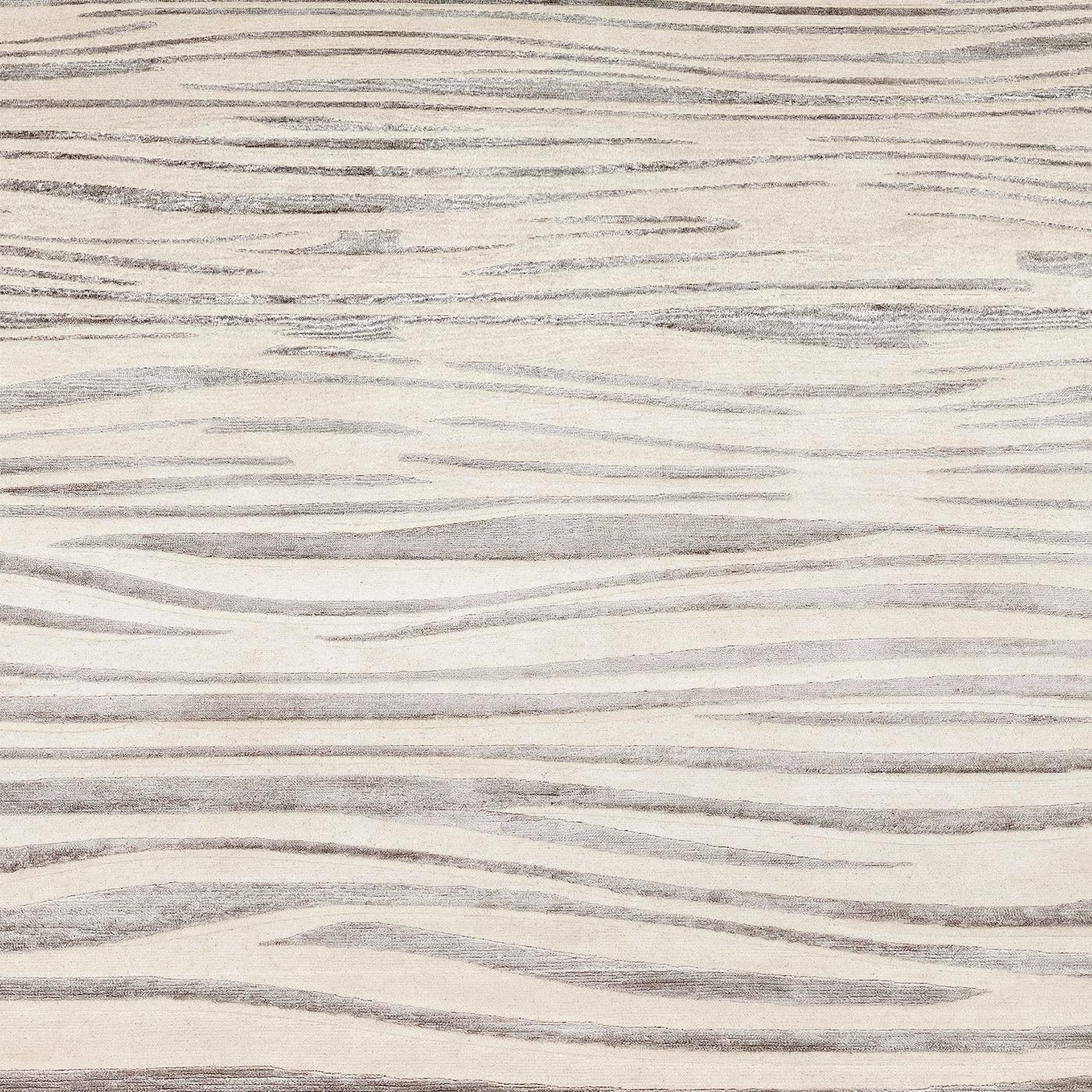 This exquisite rug depicts an alluring motif of sinuous stripes, whose irregular shape reminds of dangerous yet seductive flames. Part of a series of unique pieces hand-knotted in Nepal of 50% silk and 50% Himalayan wool, it features a base that is