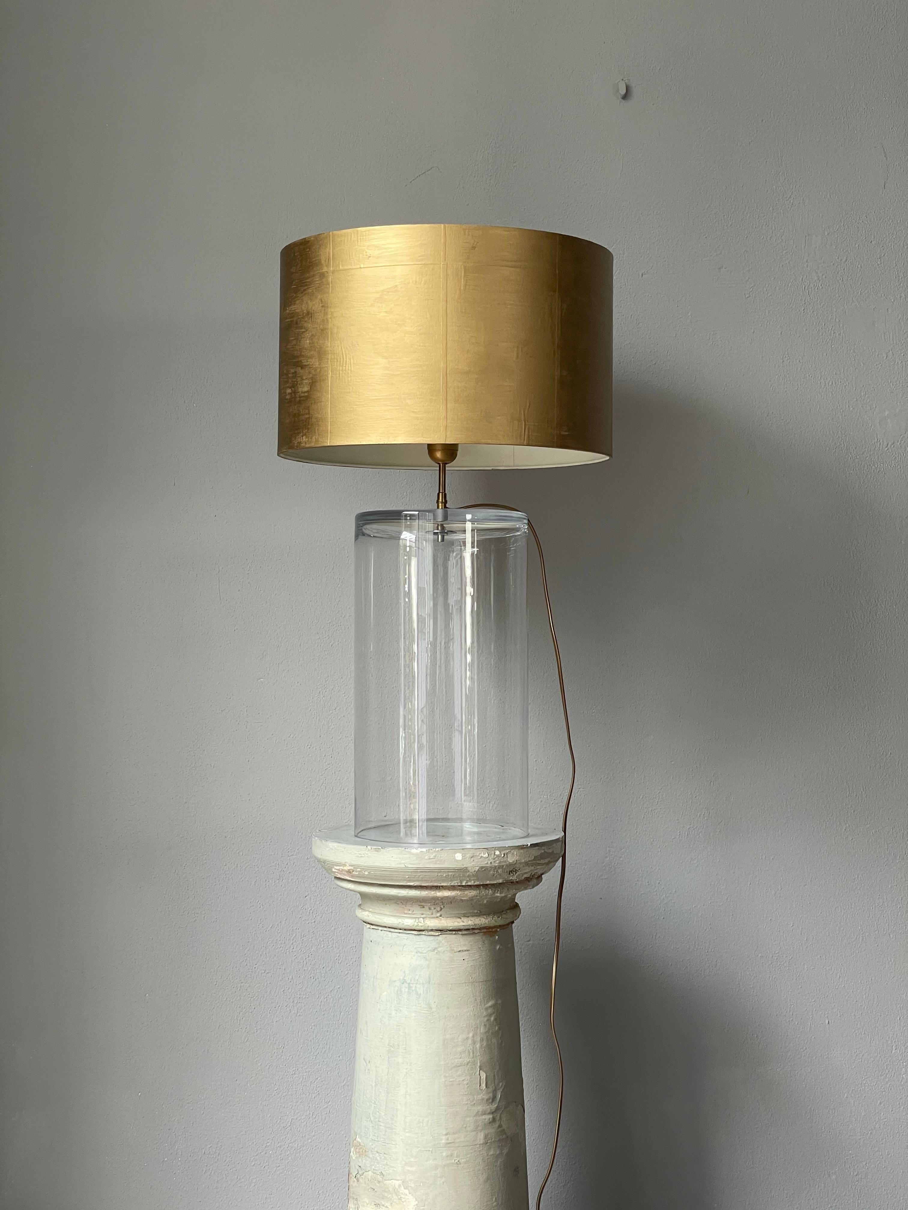 Table Lamp on an empty glass cylinder. Beautiful golden cover. 