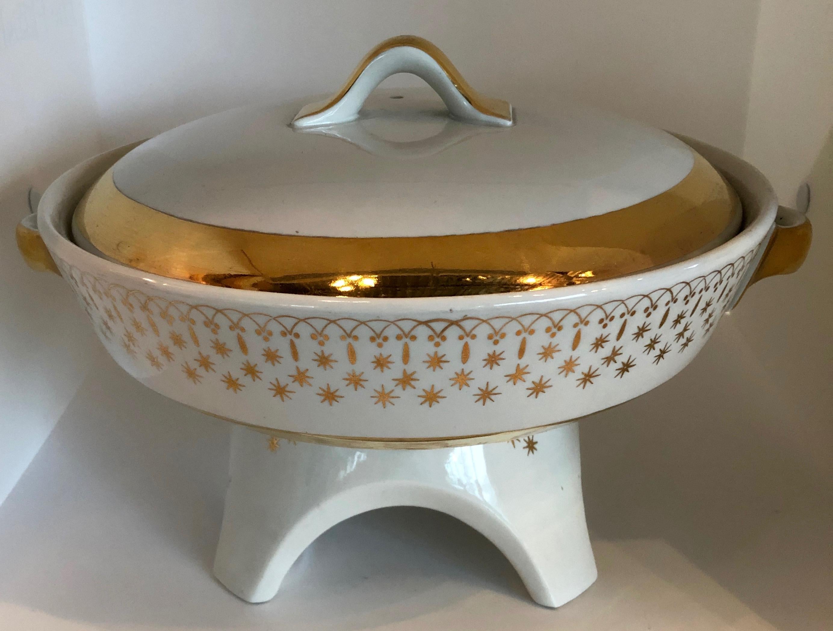 Offered is a Mid-Century Modern beyond gorgeous white and gold gilt accents porcelain Chafing dish / fondue pot by Hall China. The chafing dish / fondue pot is complete with a burner, candle and lid with gilt handle. The pot is adorned with a very