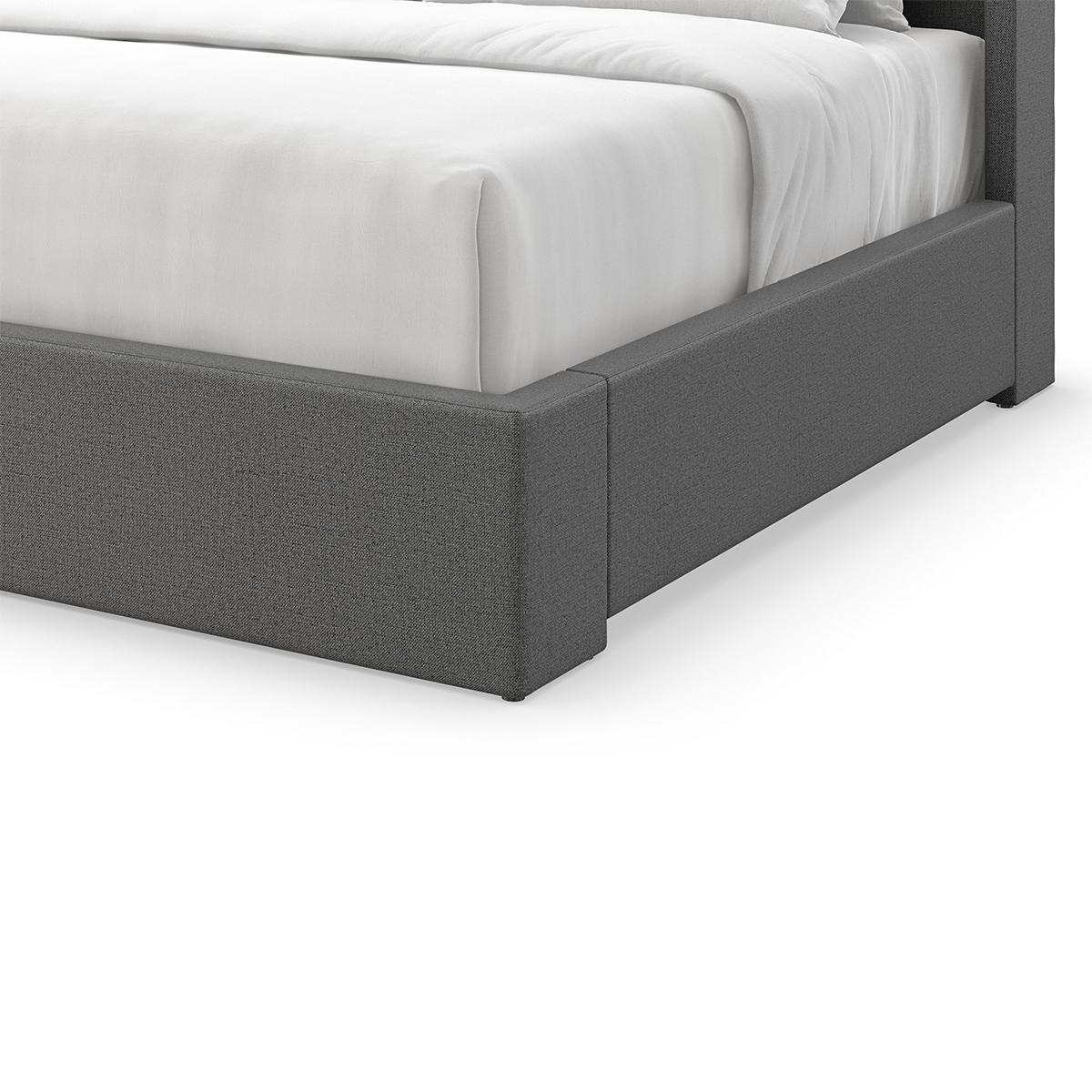 An elegant US king-sized upholstered bed frame featuring a high headboard that is flared out and curves gently at the sides. The frame is wrapped in a dark grey fabric with a subtle textured finish, which suggests a contemporary design that could