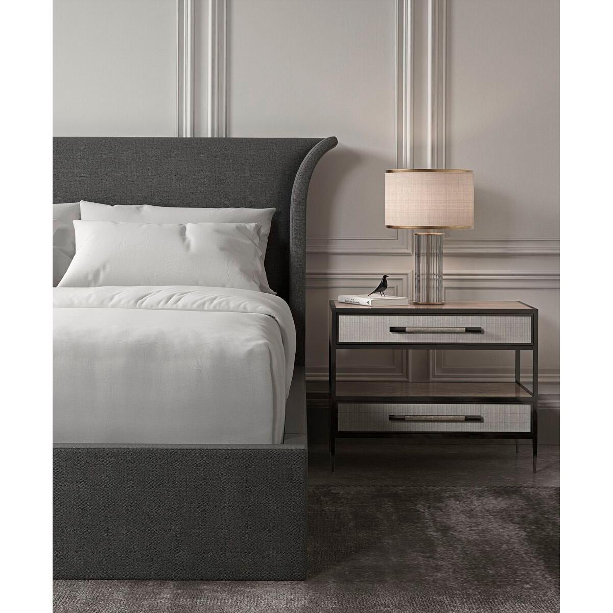 An elegant US queen-sized upholstered bed frame featuring a high headboard that is flared out and curves gently at the sides. The frame is wrapped in a dark grey fabric with a subtle textured finish, which suggests a contemporary design that could
