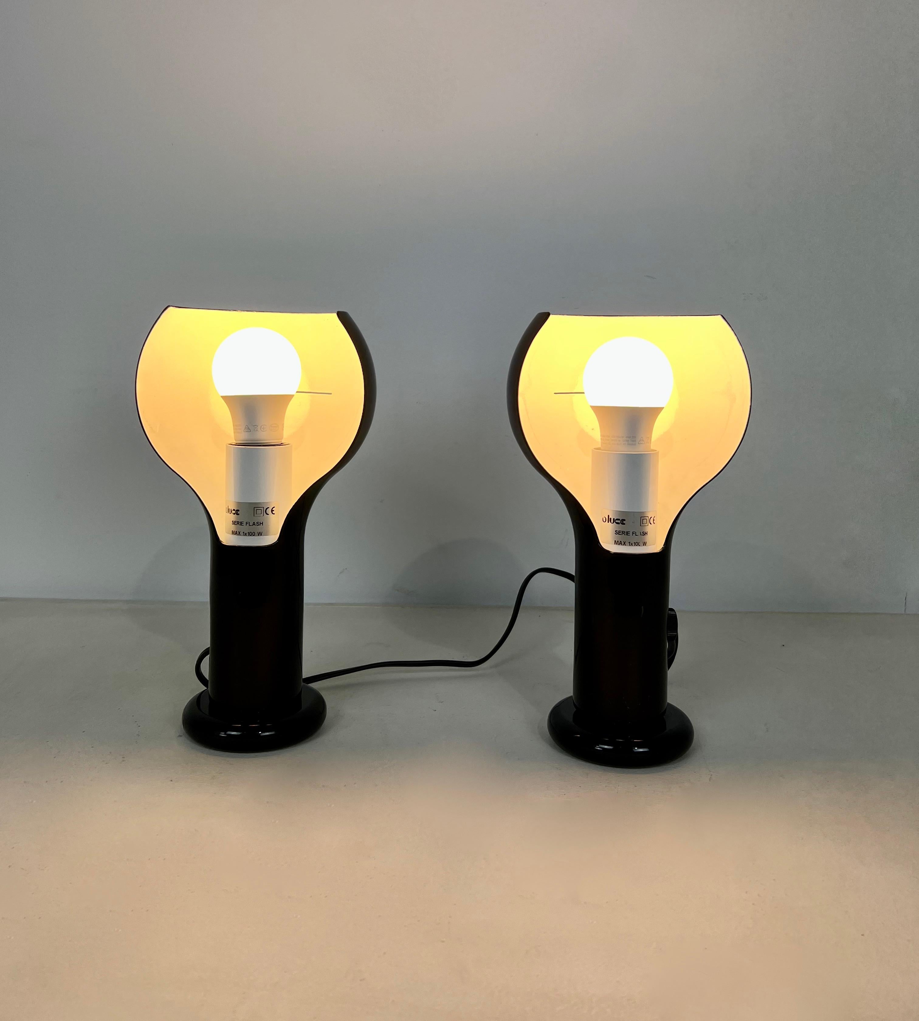 Pair of black metal lamps. Stamped Oluce ( see picture) One lamp has no dimmer ( see picture) Wear due to time and age of the lamp.