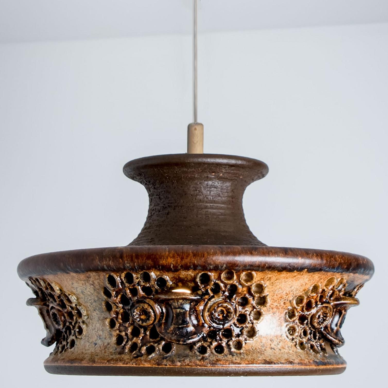 Stunning round hanging lamp with an unusual shape, made with rich brown colored beige ceramics, manufactured in the 1970s in Denmark. We also have a multitude of unique colored ceramic light sets and arrangements, all available in the frontstore. 