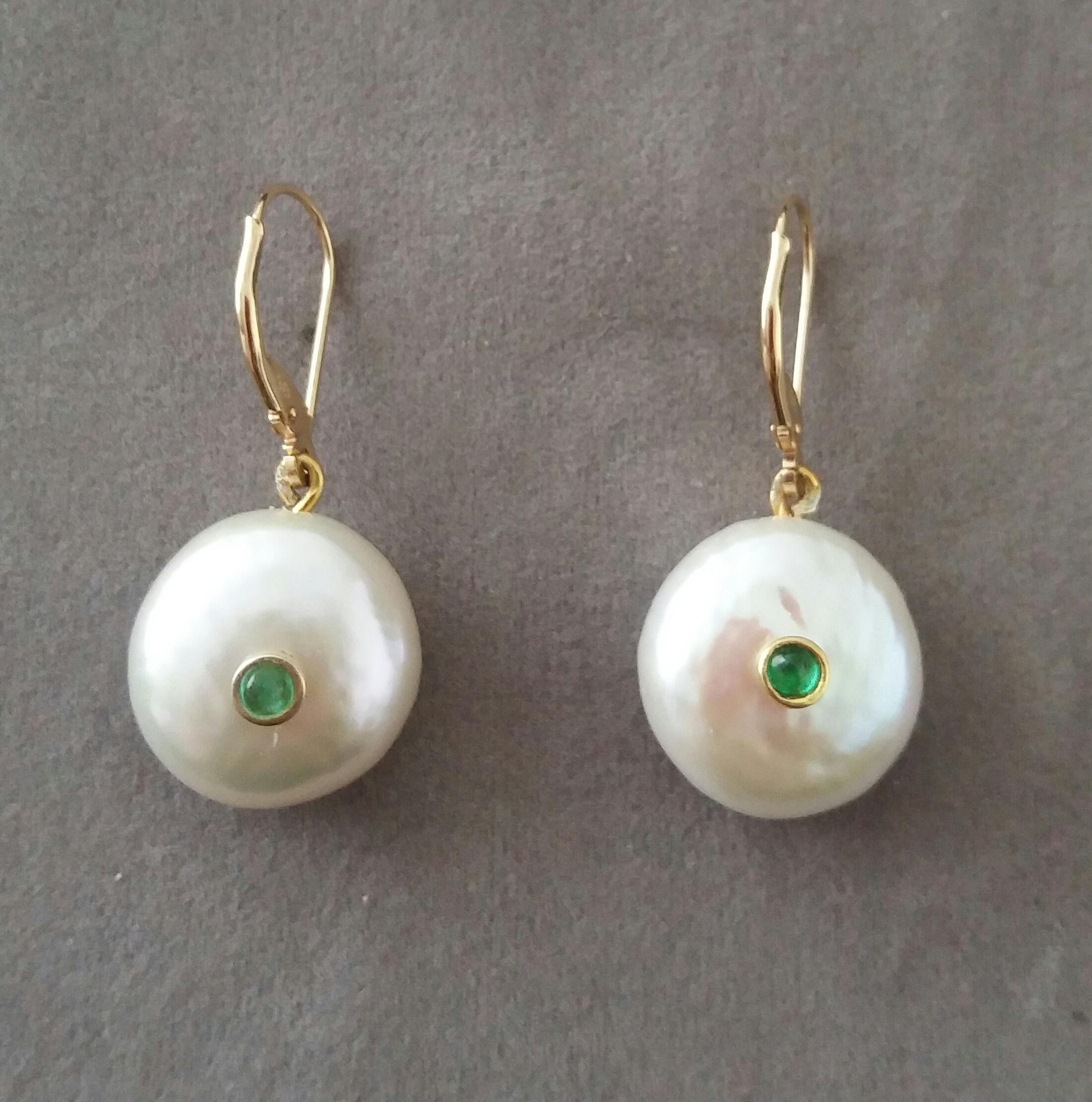 Simple chic earrings composed of 2 Flat Round Fresh Water Pearls of 16 mm in diameter with a small Emerald round cabochons in the center suspended by a pair of 14 K yellow gold clip.

In 1978 our workshop started in Italy to make simple-chic Art