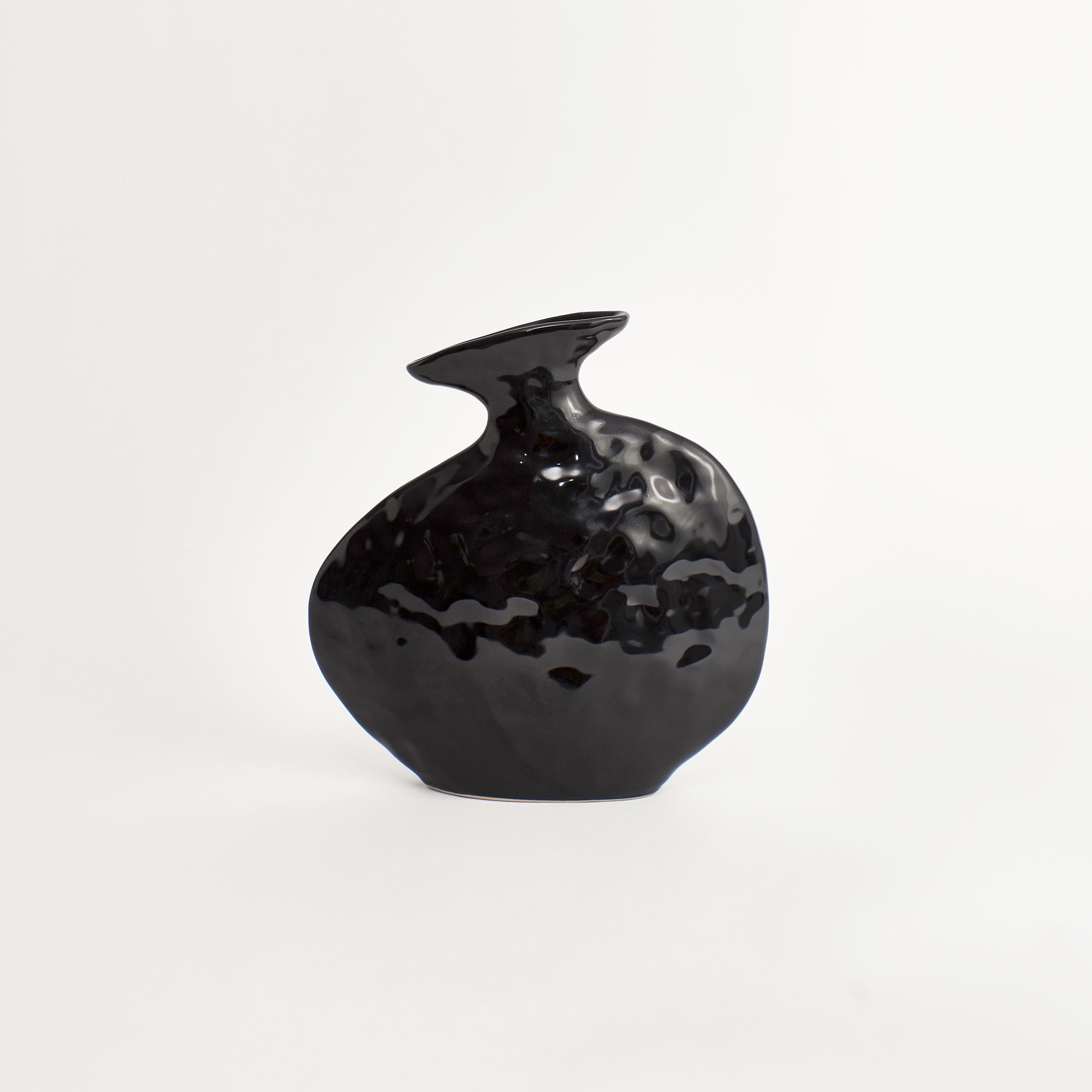 Flache Vase in Shiny Black.
Entworfen von Project 213A im Jahr 2021.
Handgefertigtes Steingut.


Die Schöpfung verlangt nach Zerstörung, sie nimmt das Alte und Typische, um das Neue und Besondere zu schaffen. Die flache Vase verkörpert durch ihre