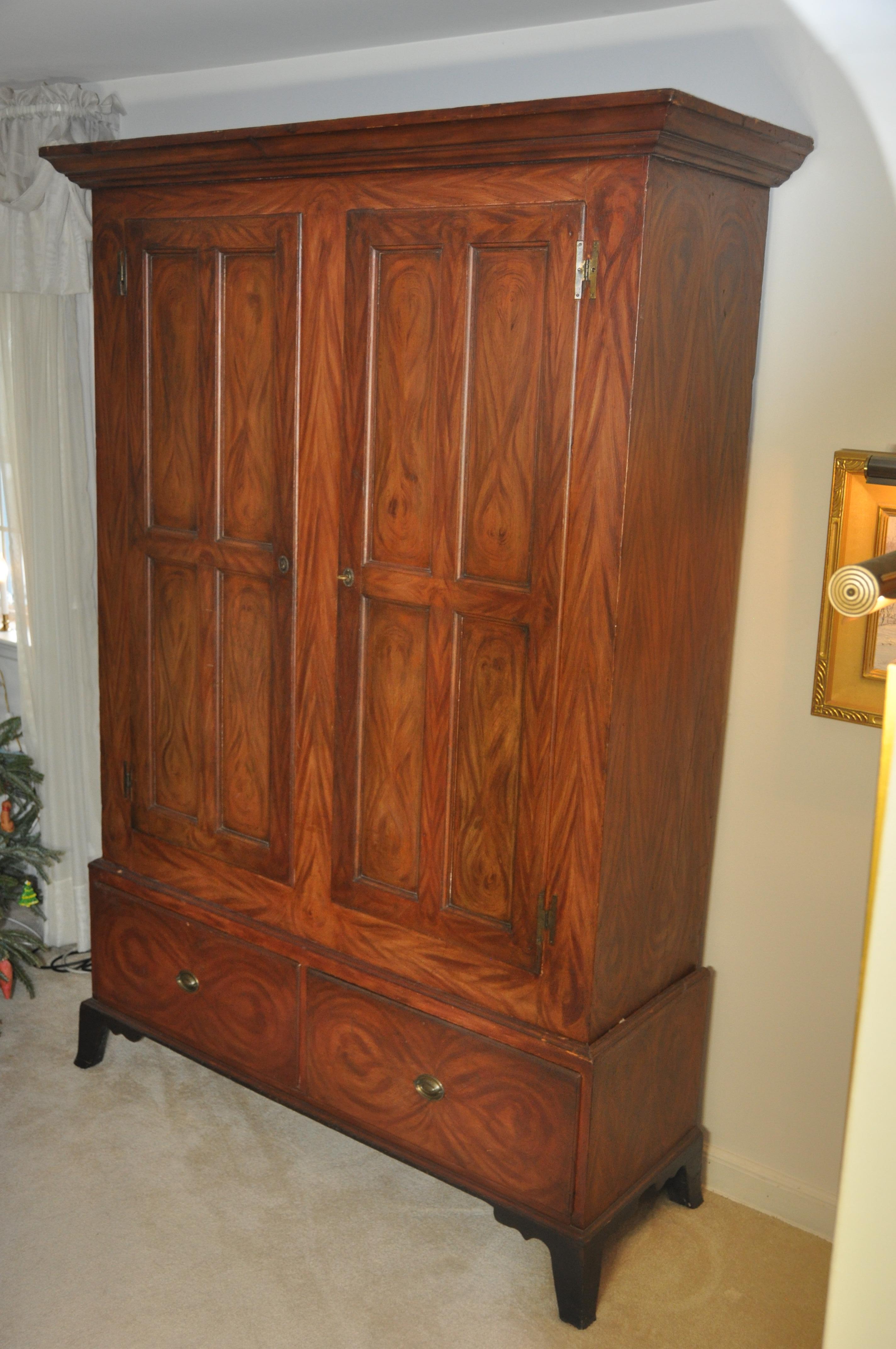 Flat wall cupboard two-piece Salomon fancy paint decoration, circa 1800.
In two part construction two doors over two drawers standing on French bracket feet original fancy grained paint decoration.
Southeastern Pennsylvania, pine an popular. 
 