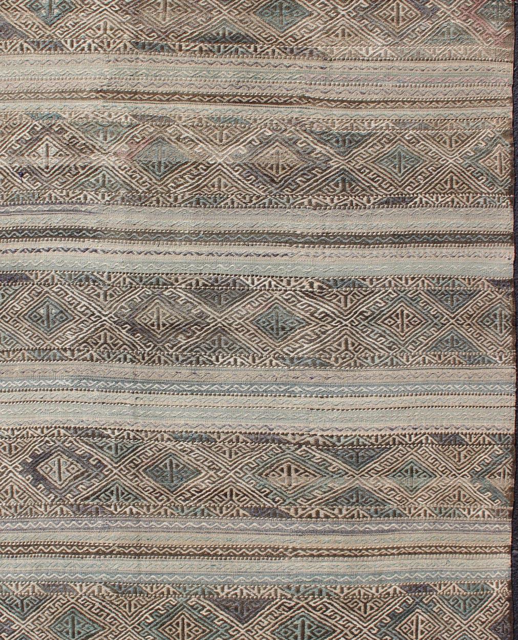 Vintage flat-weave Kilim with embroideries with a modern design in tan, brown, green and blue
geometric stripe design Vintage Kilim from Turkey, rug EN-179526, country of origin / type: Turkey / Kilim, circa 1950

This vintage Turkish Kilim rug