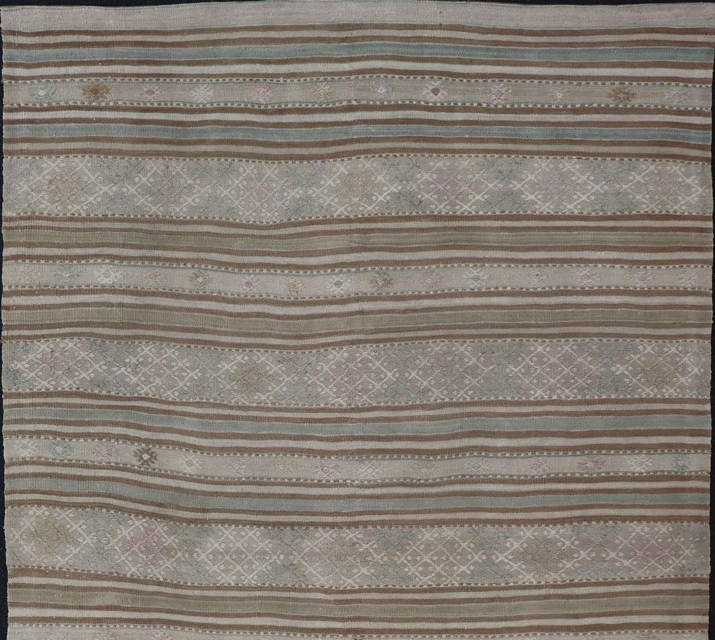 Kilim vintage à tissage plat avec des broderies au design moderne dans les tons beige, brun, vert et bleu
dessin de rayures géométriques Kilim vintage de Turquie, tapis EN-179257, pays d'origine / type : Turquie / Kilim, circa 1950

Ce tapis