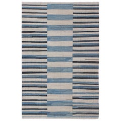 Rug & Kilim a trama piatta con design a strisce classiche in blu, avorio e carbone.
