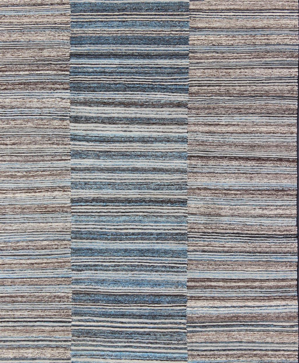 Modern flat-weave Kilim rug with stripes in shades of light blue, charcoal, blue, cream. Keivan Woven Arts Rug AFG-21579, country of origin / type: Afghanistan / Kilim

This flat-woven Kilim rug features a Classic stripe design that places
