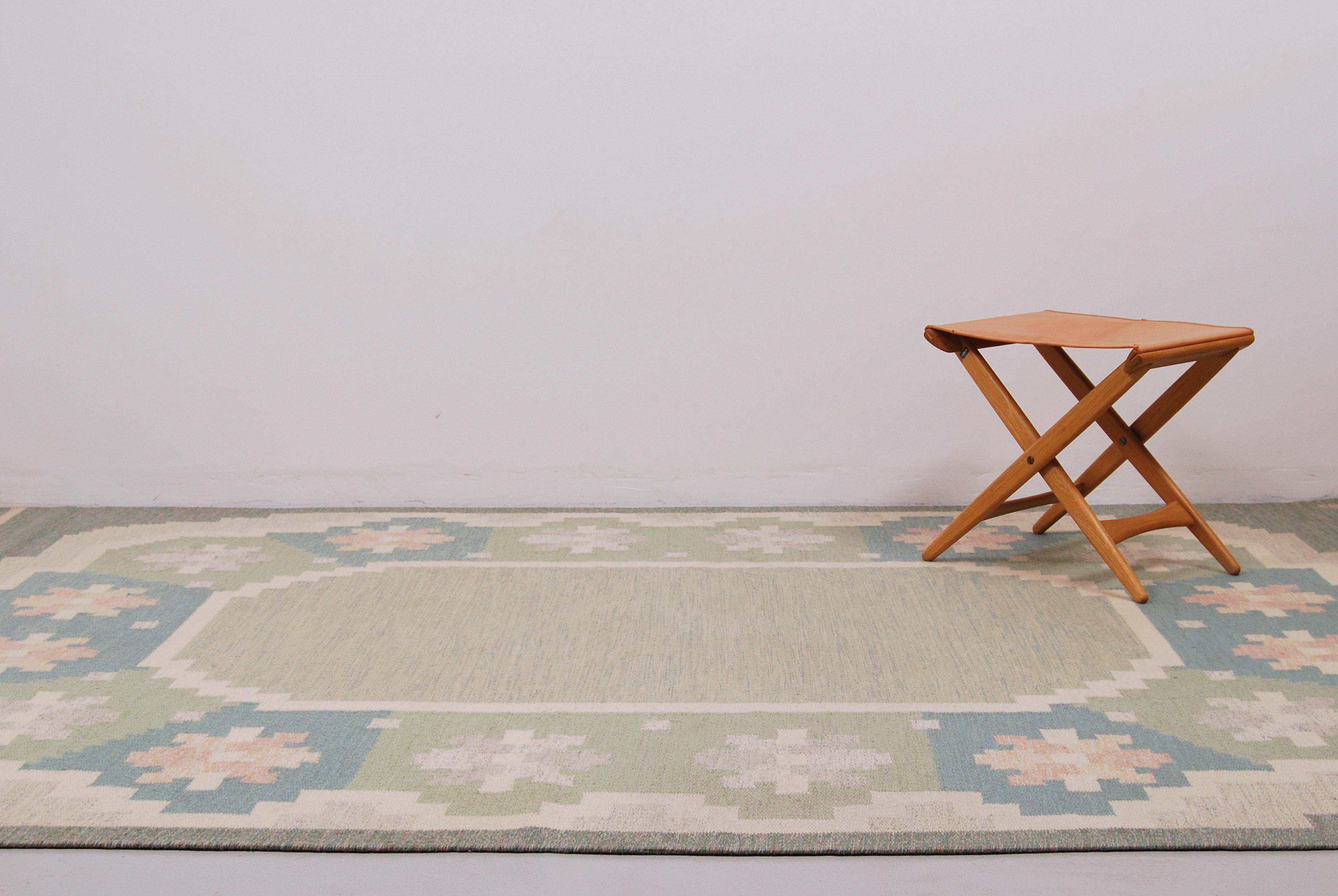 This large flat-weave Rölakan carpet was designed by Anna Johanna Ångström and made by hand in Sweden during the 1960s. It has fields in different shades of green, blue, white and pink and was woven in wool. Signed ”Å” to the right hand corner.