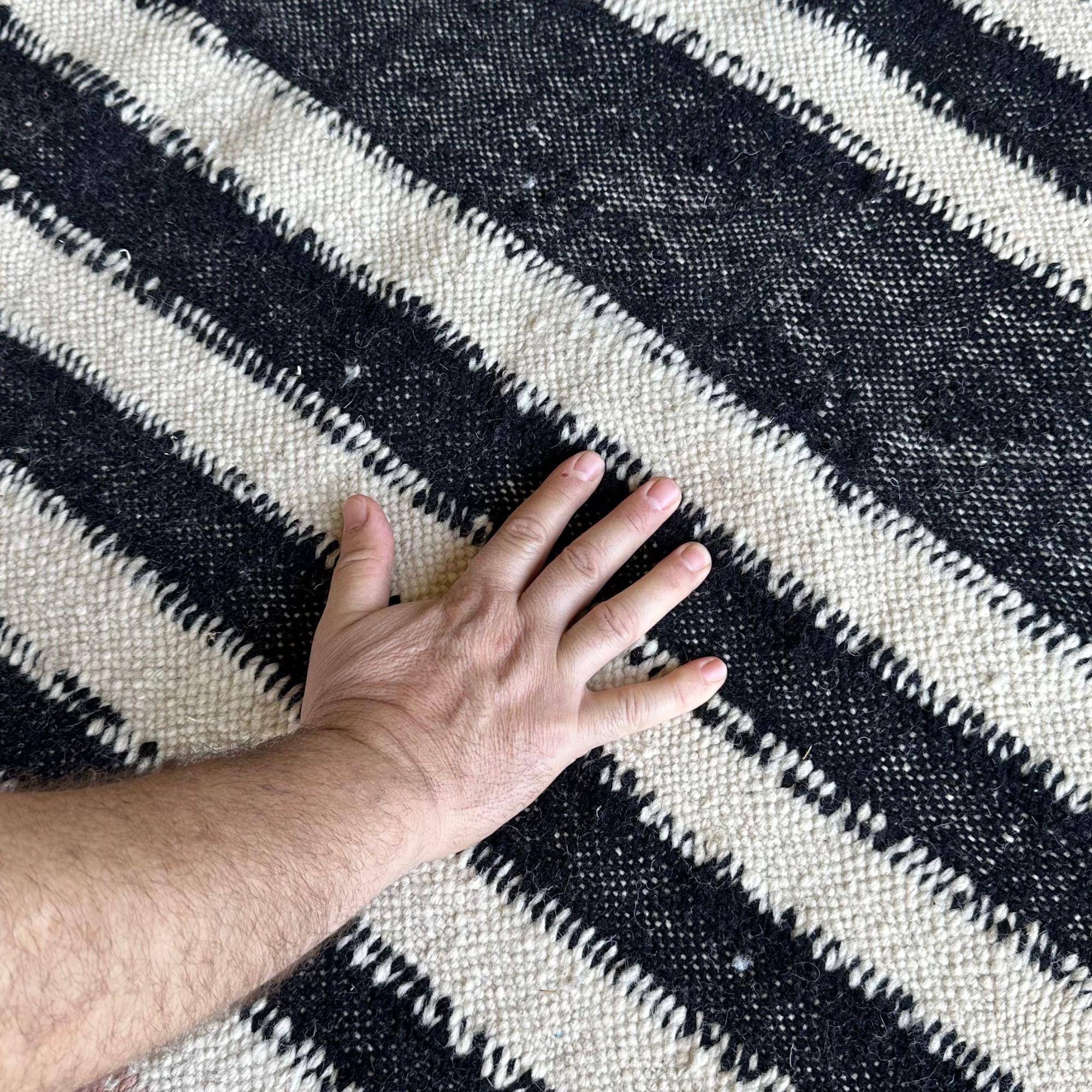 Discover the timeless allure of the Mystique Beauty Flat Weave Rug, meticulously handcrafted to blend tradition with modern elegance. This rug is a true centerpiece for your living space.

Its intricate geometric design, showcasing bold black and
