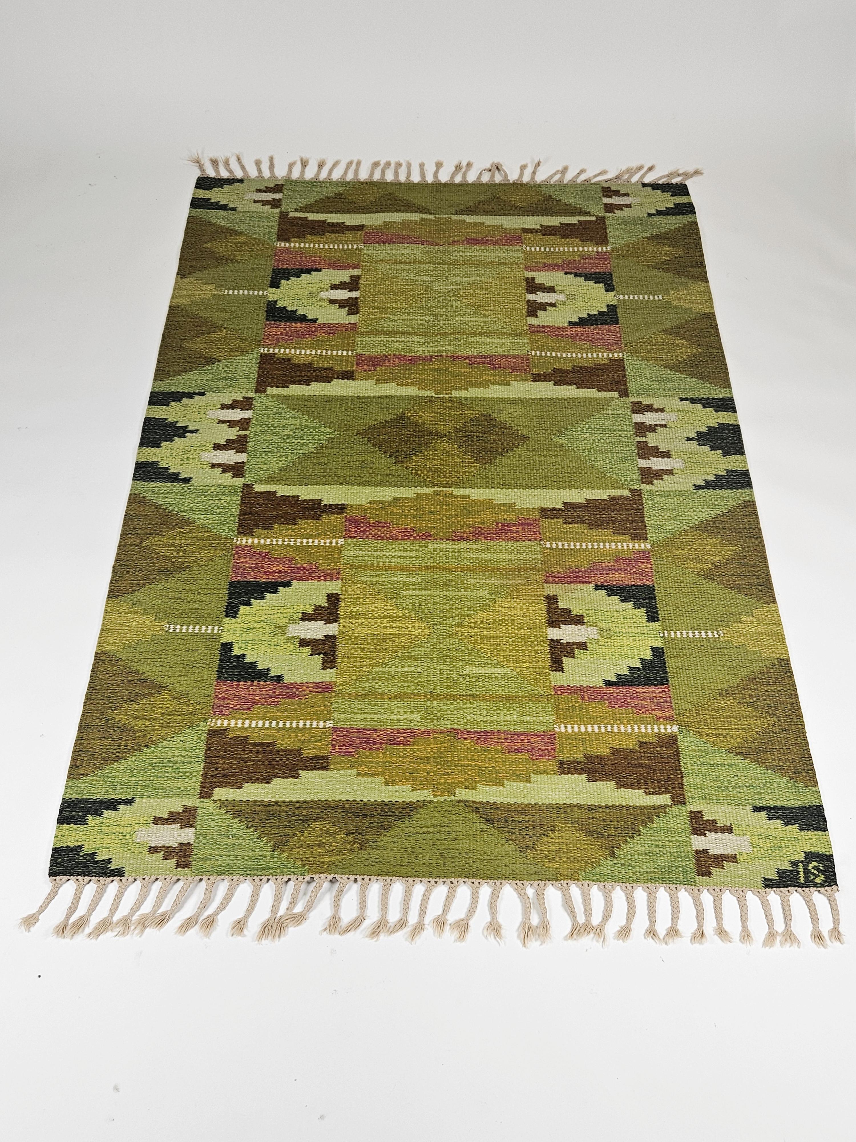 Mid-20th century Swedish flatweave carpet designed by Ingegerd Silow. 

Navajo-styled pattern. Made in wool with beautiful green colors. 

Good vintage condition with all fringes still whole. 