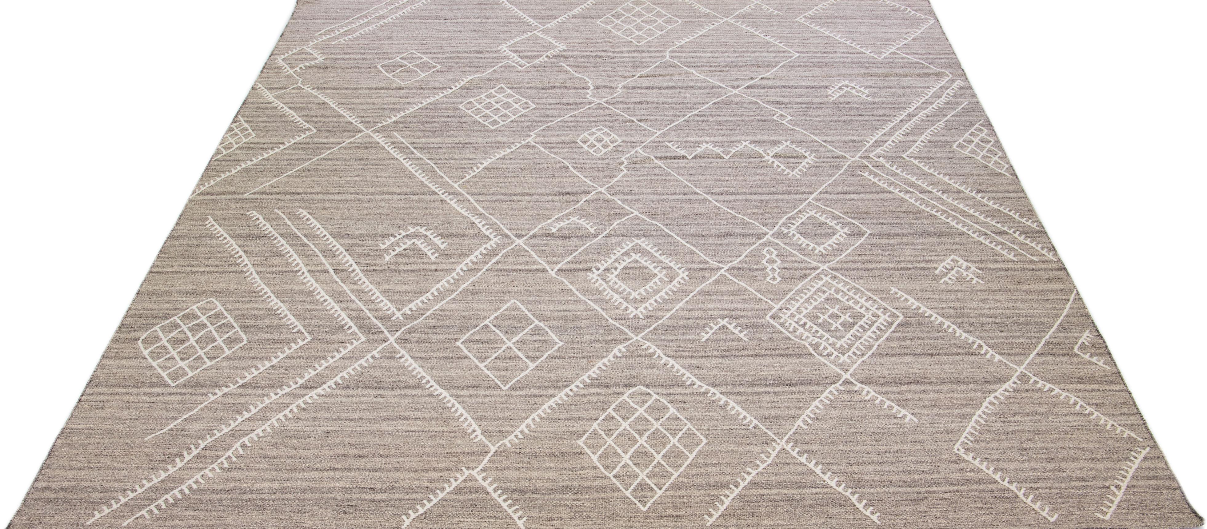 Beautiful kilim handmade wool rug with a beige-taupe color field. This custom modern flatweave rug of our Nantucket collection has white accents and a gorgeous, all-over geometric coastal design.

This rug measures: 10'2