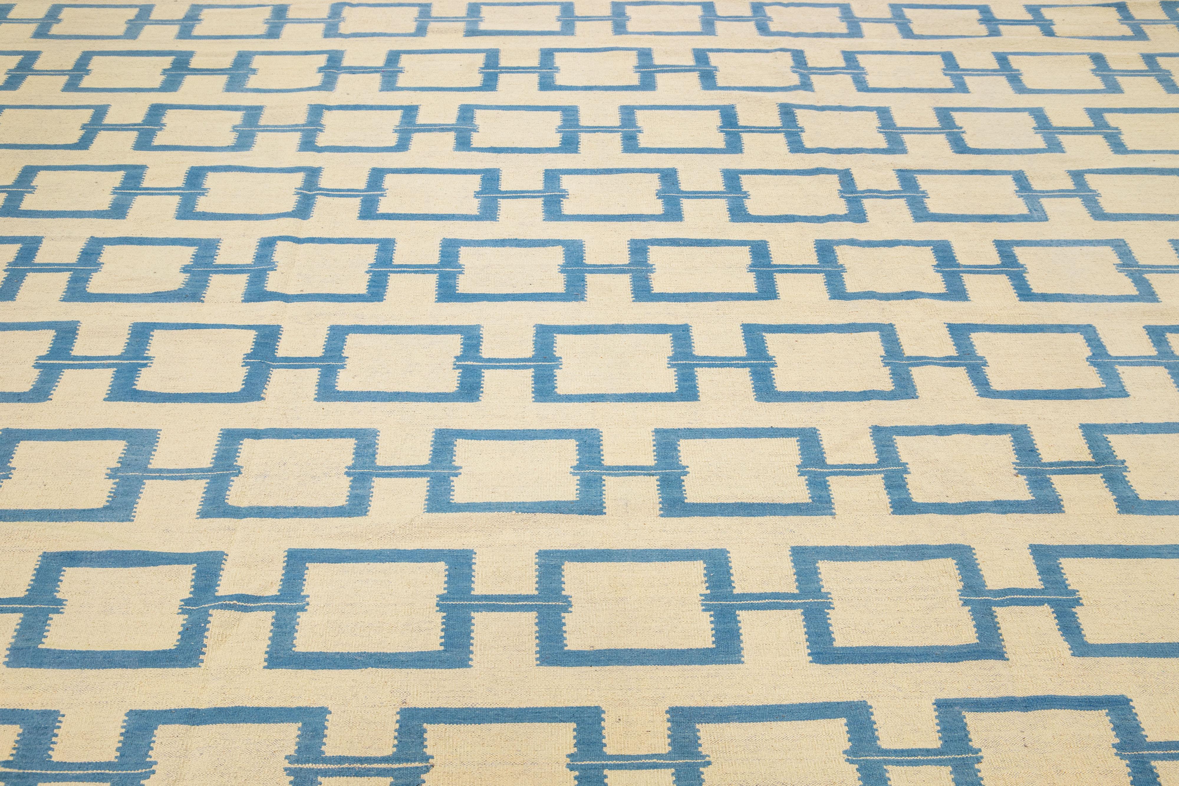 This contemporary Kilim rug is meticulously handwoven with a dominant beige field, highlighted by intricate geometric patterns in shades of blue, providing subtle yet elegant accents.

This rug measures 10'4