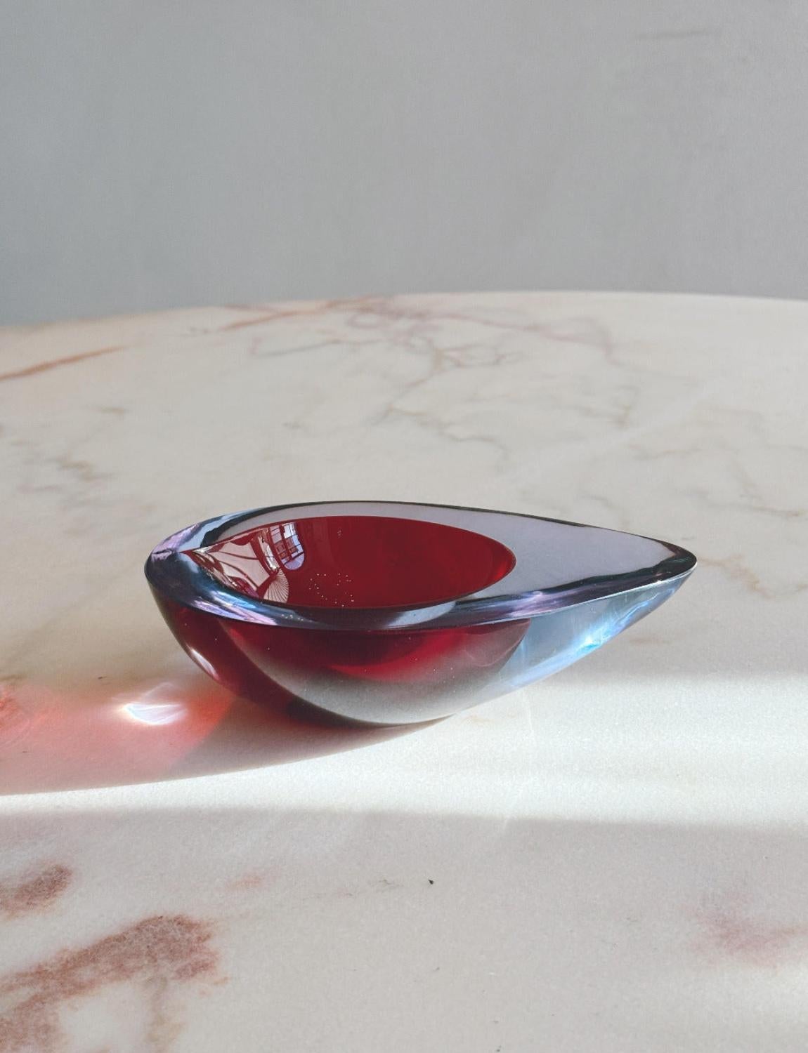Questa meravigliosa ciotola ovale/ovale di Flavio Poli è stata soffiata a mano negli anni '60 con la tecnica del sommerso. Il vetro circostante è rosa con un nucleo rosso intenso. Una ciotola in vetro di Murano molto particolare e in ottime