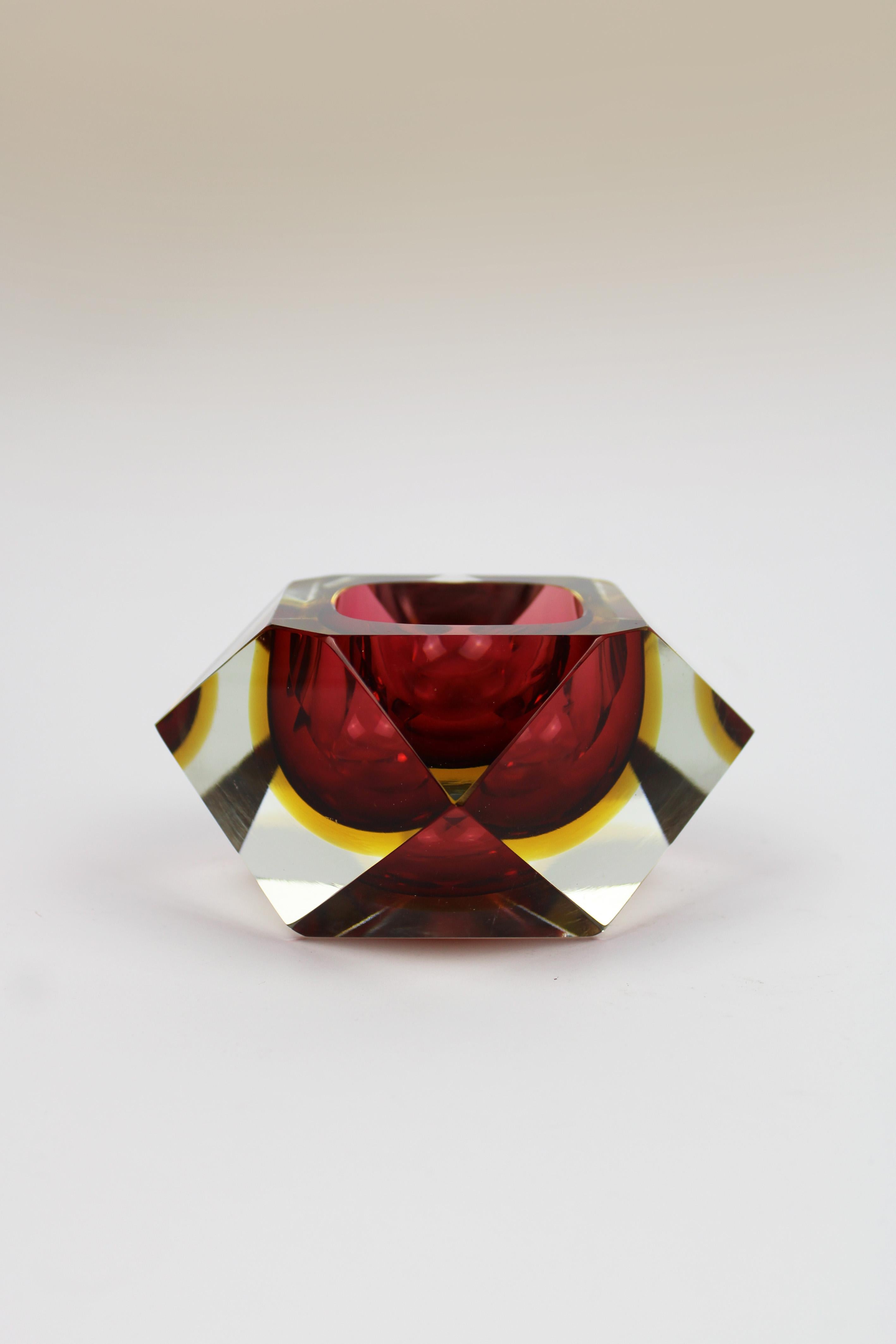 Presentamos un raro y sorprendente cenicero o vide poche de los años 60, diseñado por el ilustre Flavio Poli. Esta exquisita pieza está hecha de cristal de Murano, con un cautivador cuenco de cristal facetado amarillo y rojo que resalta el vibrante