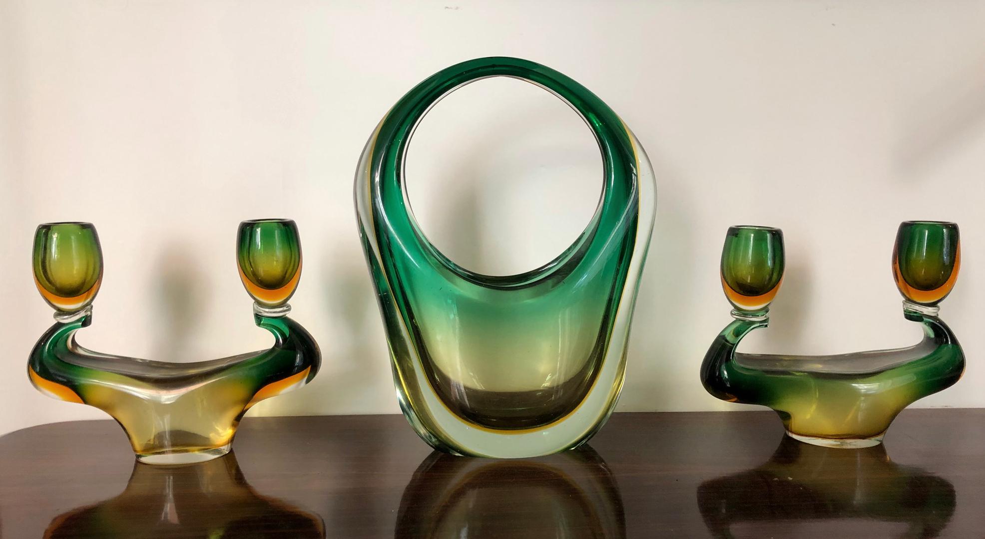 Wonderful triptych in green and yellow submerged Murano glass designed by Flavio Poli for Seguso, consisting of a basket vase and two candelabras.
The candelabra measure: 18 x 21 x 6 cm.