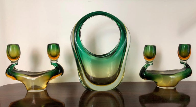 Wonderful triptych in green and yellow submerged Murano glass designed by Flavio Poli for Seguso, consisting of a basket vase and two candelabras.
The candelabra measure: 18 x 21 x 6 cm.