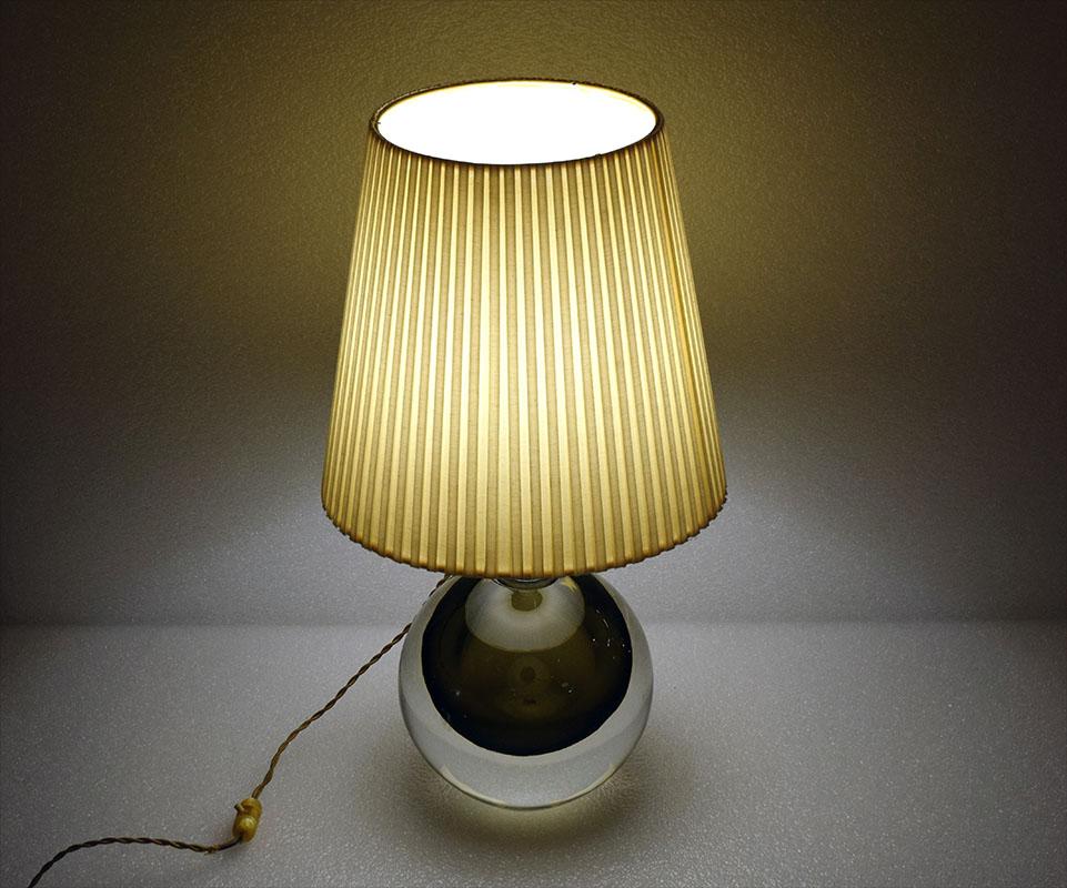 Flavio Poli for Seguso Murano, 1950s table lamp.
Solid sommerso glass sphere, pleated fabric lampshade, original electrical system.
Engraved signature on the bottom.
In excellent condition.
25 is the diameter of the glass sphere.