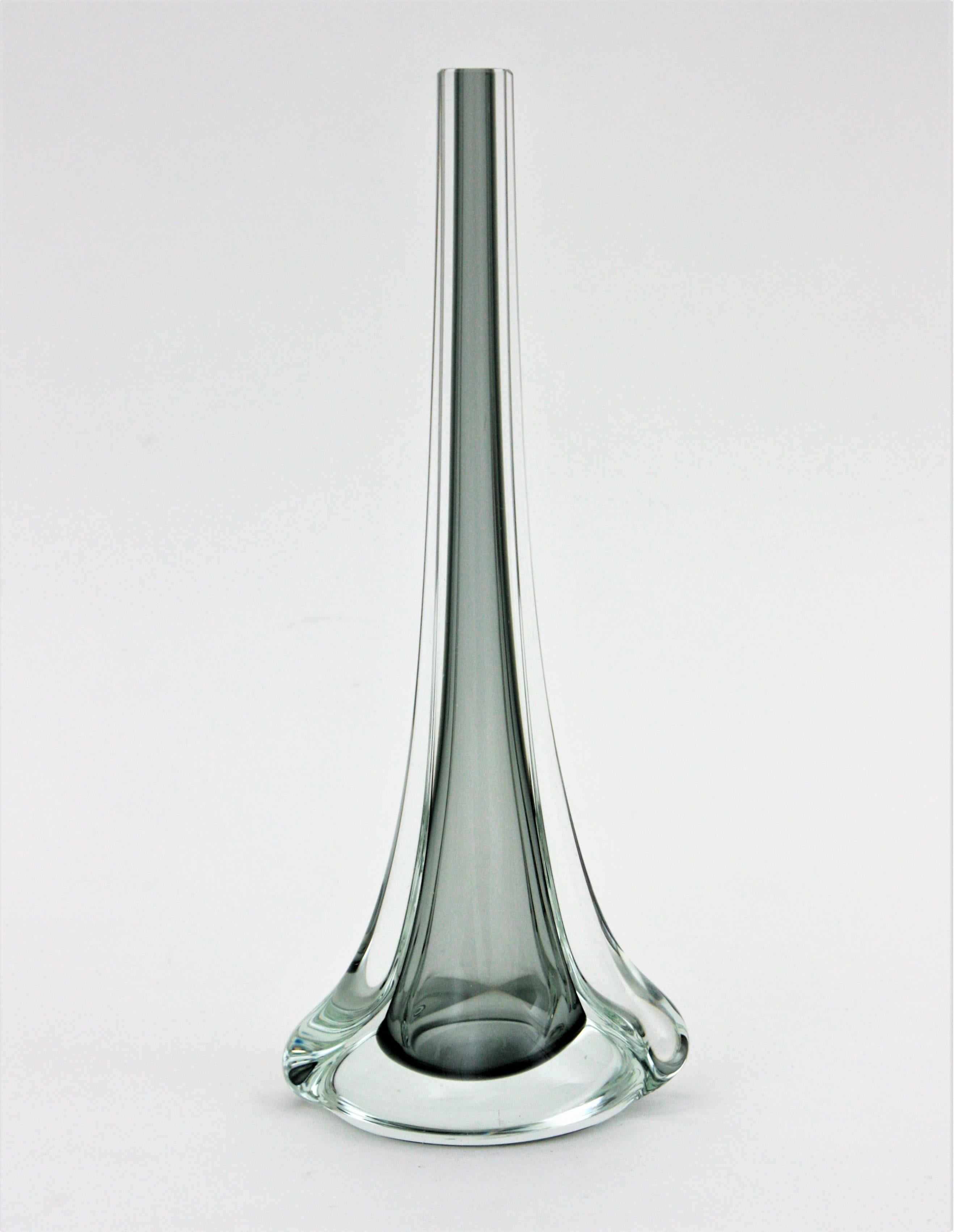 Lovely one-flower handblown Sommerso smoked grey and clear Murano glass vase. Attributed to Flavio Poli for Seguso Vetri d'Arte. Italy, 1950s.
This eye-catching vase with tall neck is made of grey glass submerged into clear glass.
Use it as single