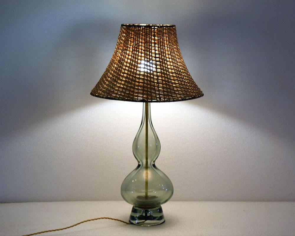 Lampe de table conçue par Flavio Poli pour Seguso Murano dans les années 1950.
Grande taille avec tige en verre soufflé gris/vert, abat-jour en osier d'origine, système électrique d'origine.
Signature gravée sur le fond.
verre h 50 x diam 25 cm - h