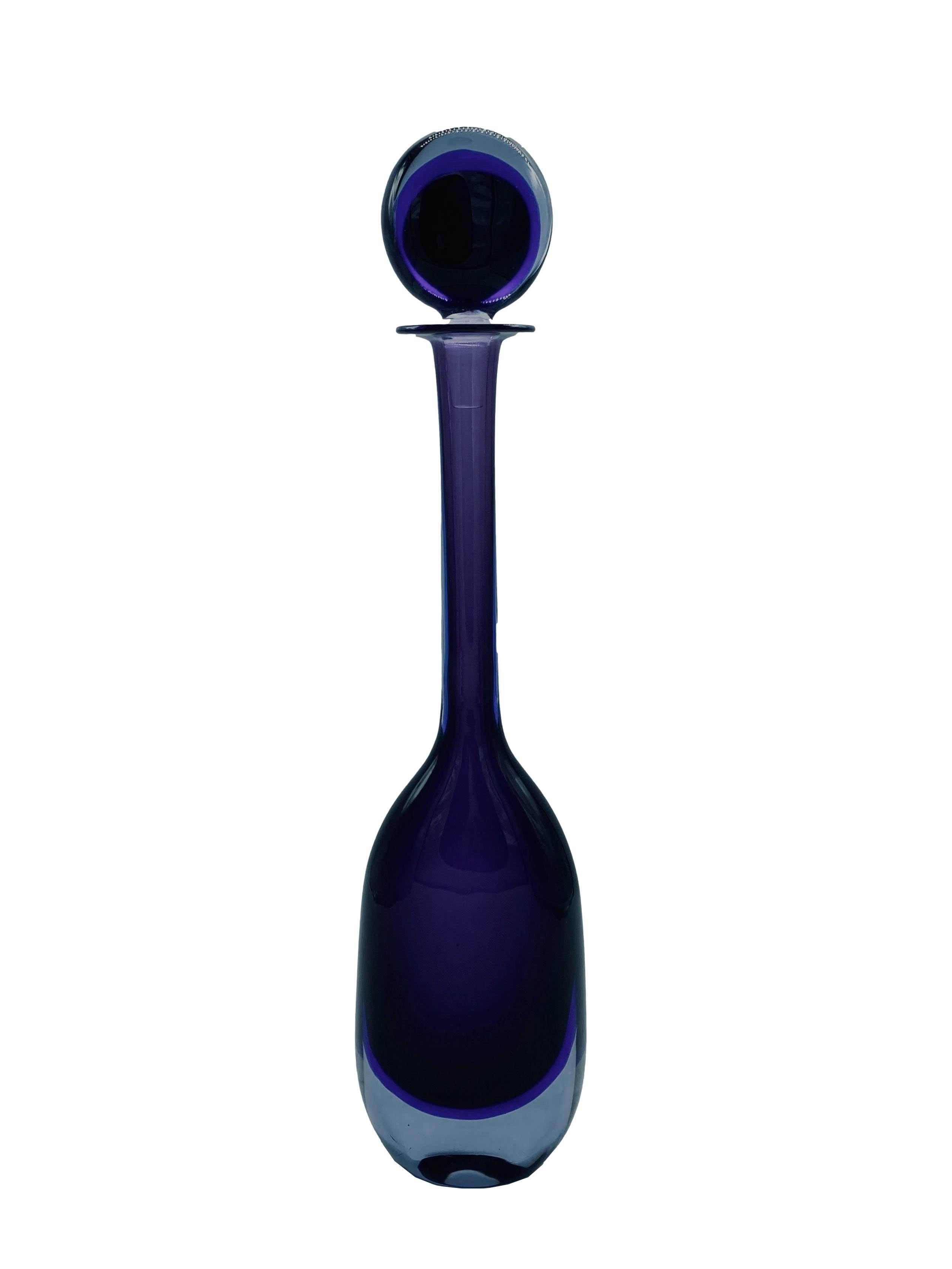 Beautiful large bottle with stopper in the popular Submerged glass technique, the design was by Flavio Poli for Seguso Vetri d'Arte in the 1950s-1960s. Purple glass in a very elegant teardrop shape.