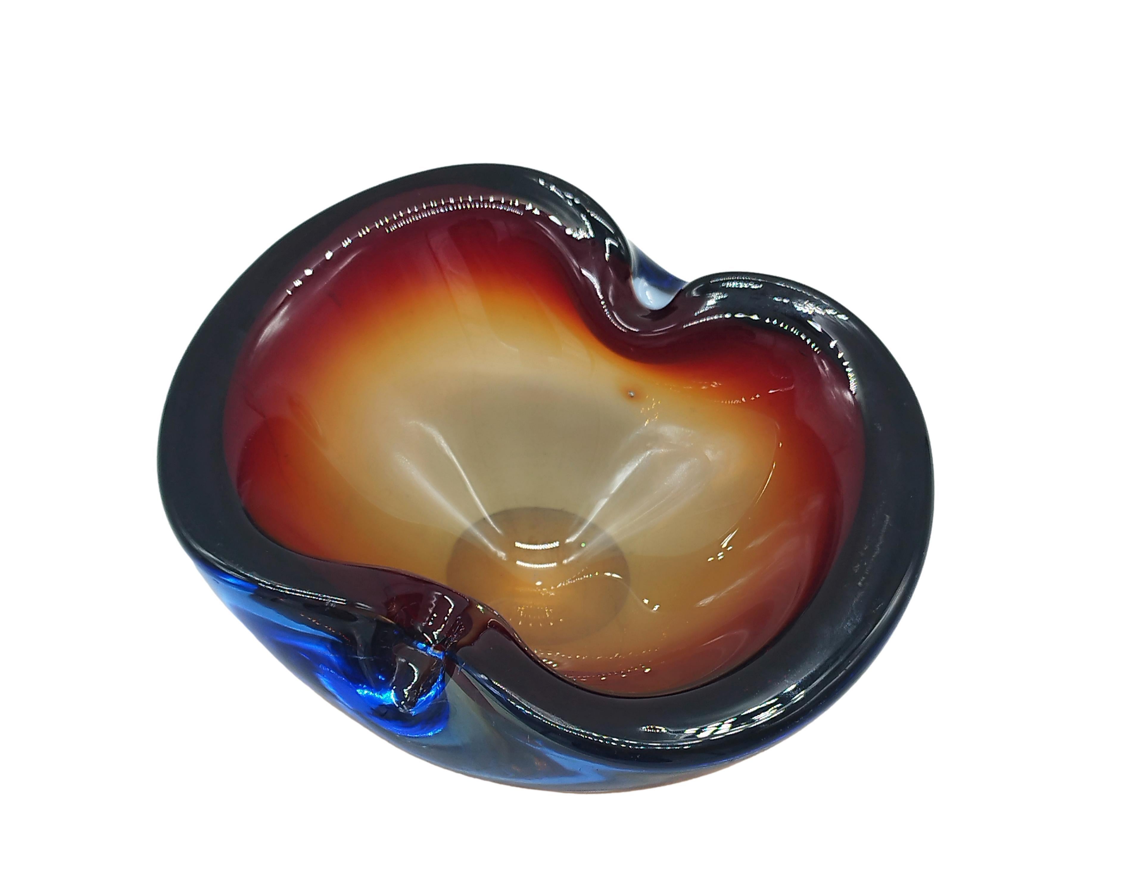 Hand-blown submerged Murano art glass bowl or ashtray , period circa 1950s, Italy. The piece is made of blue, rosSo and orange art glass, oval in shape, with two indentations on the rim. Great as an ornament for a cocktail table, sideboard, coffee