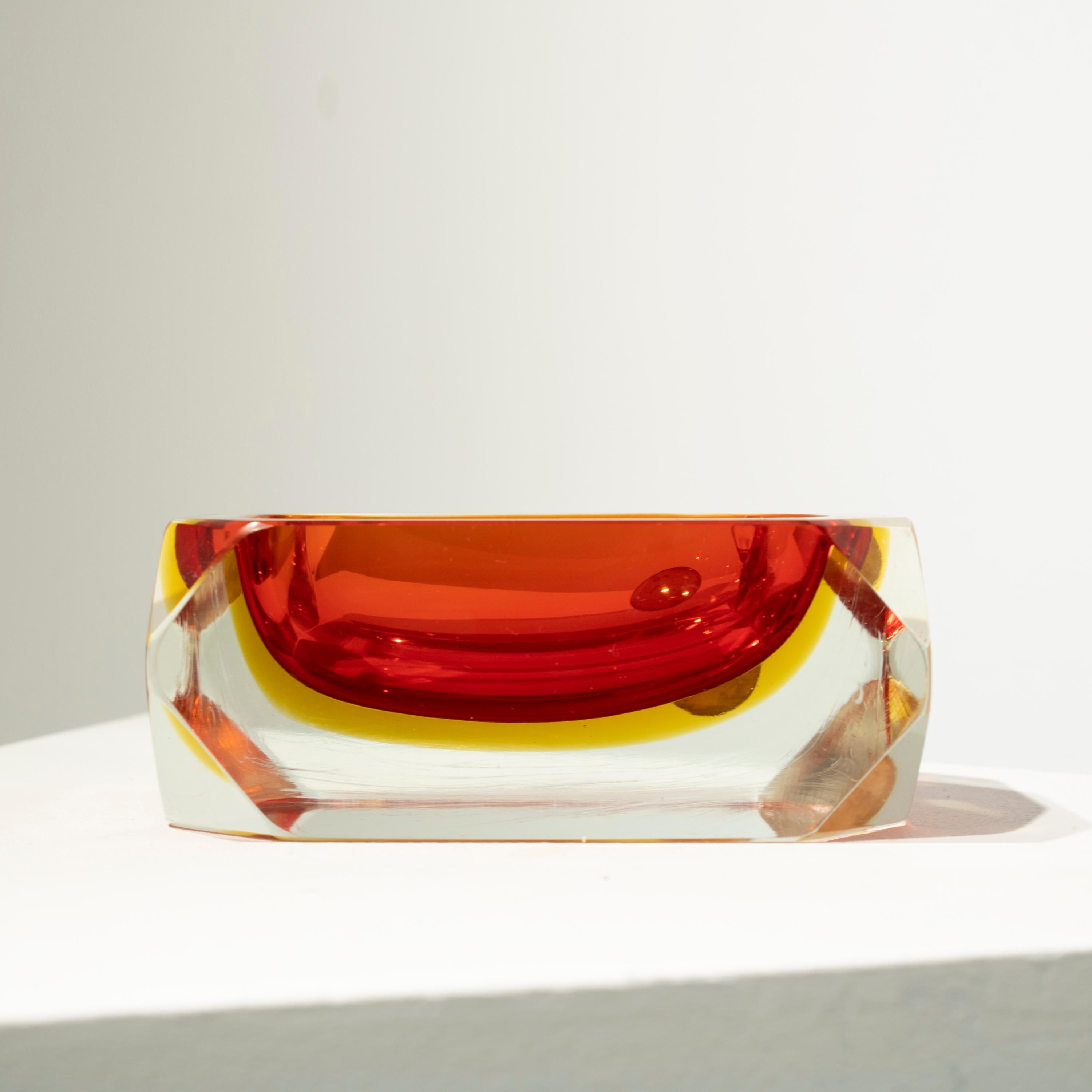 Italian small vase designed by Flavio Poli in the 1970´s. The vase is hand-crafted in faceted Murano glass with a rectangular shape, in different colors with predominant red.