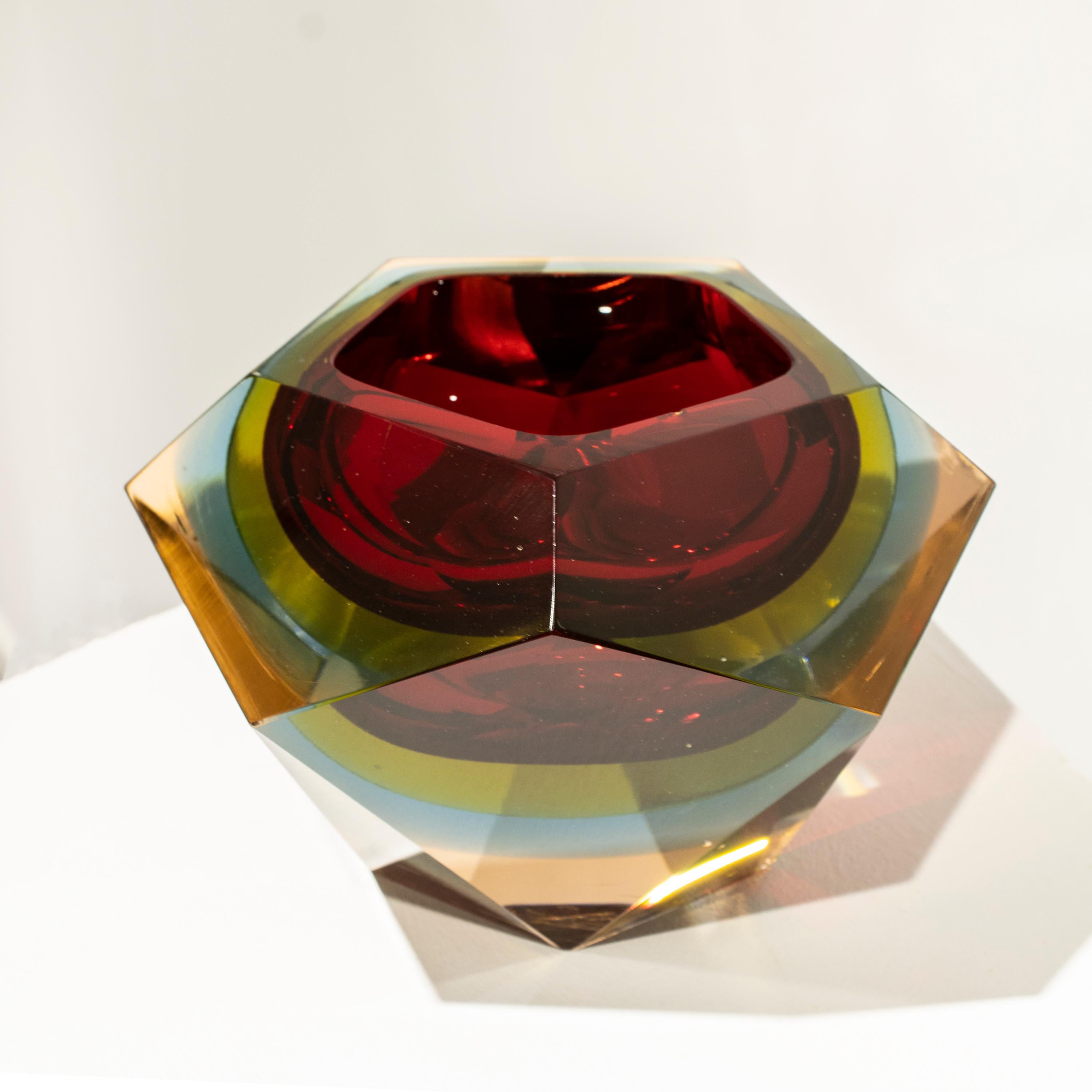Italienische Vase, entworfen von Flavio Poli in den 1970er Jahren. Die Vase ist aus facettiertem Murano-Glas mit einer polygonalen Form in verschiedenen Farben mit überwiegendem Rot handgefertigt.