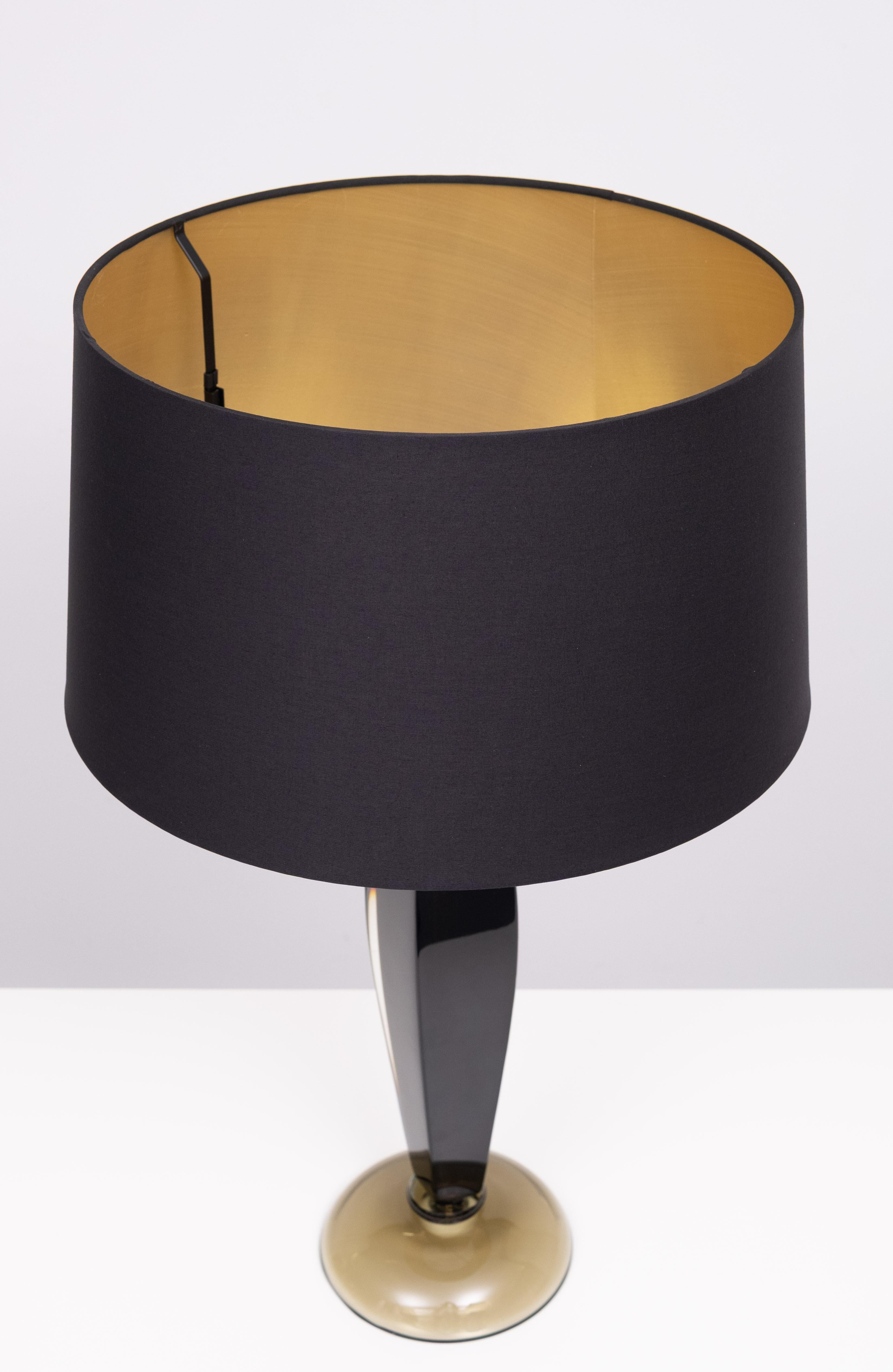 Elegante lámpara de sobremesa de cristal de Murano de los años 60, obra de Flavio Poli para Seguso. La base translúcida de color verde bosque produce un sutil efecto luminoso cuando la bombilla está encendida.   Nuevo tono .