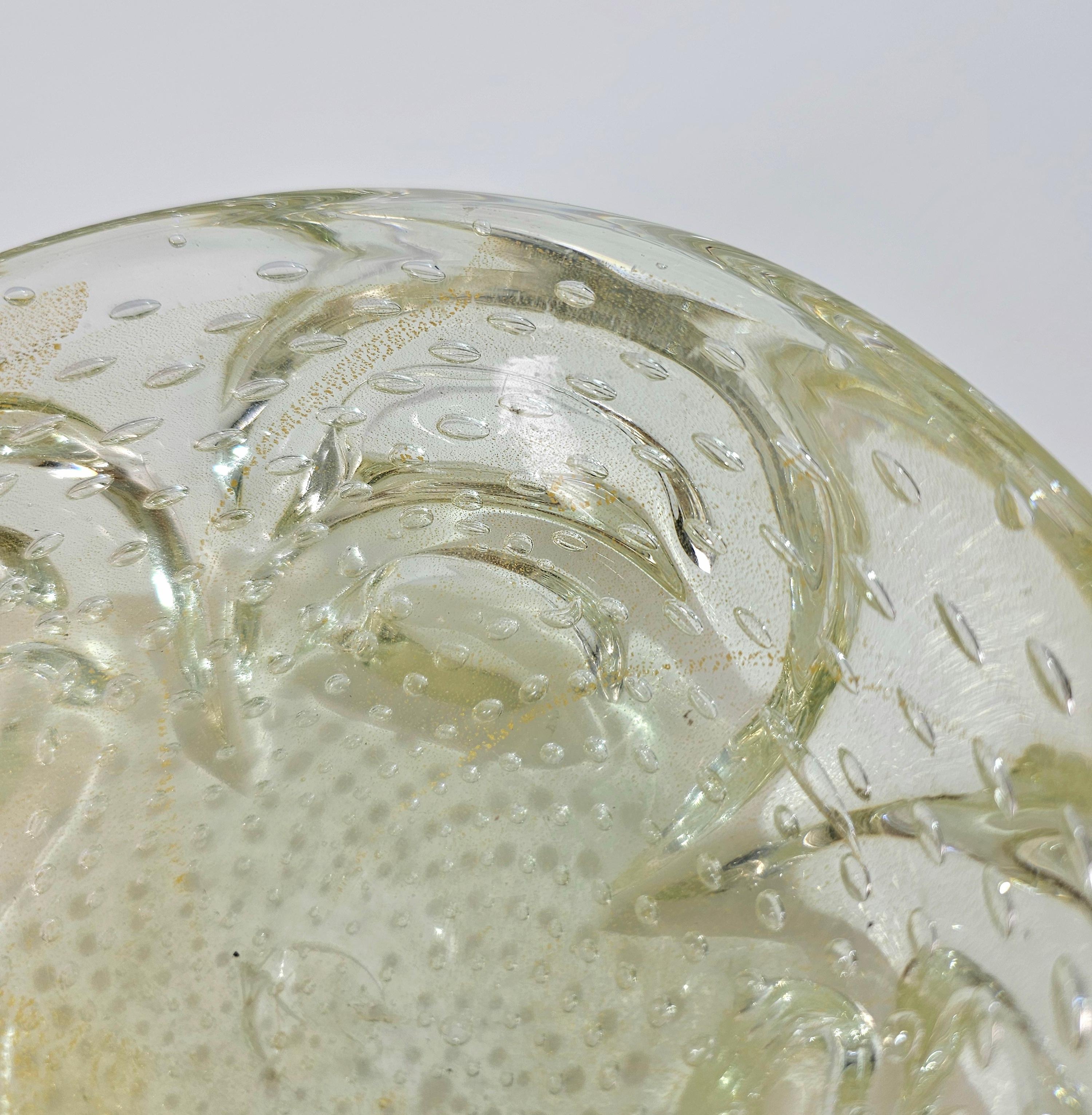 Schale aus dickem Murano-Glas. Amorphe Form in transparent mit goldenen Aventurinflocken und Bullicante-Blasen. Bitte sehen Sie sich das Video und die Fotos sorgfältig an, vielen Dank.

Gewicht: 1600 kg

HINWEIS: Wir bieten unseren Kunden einen