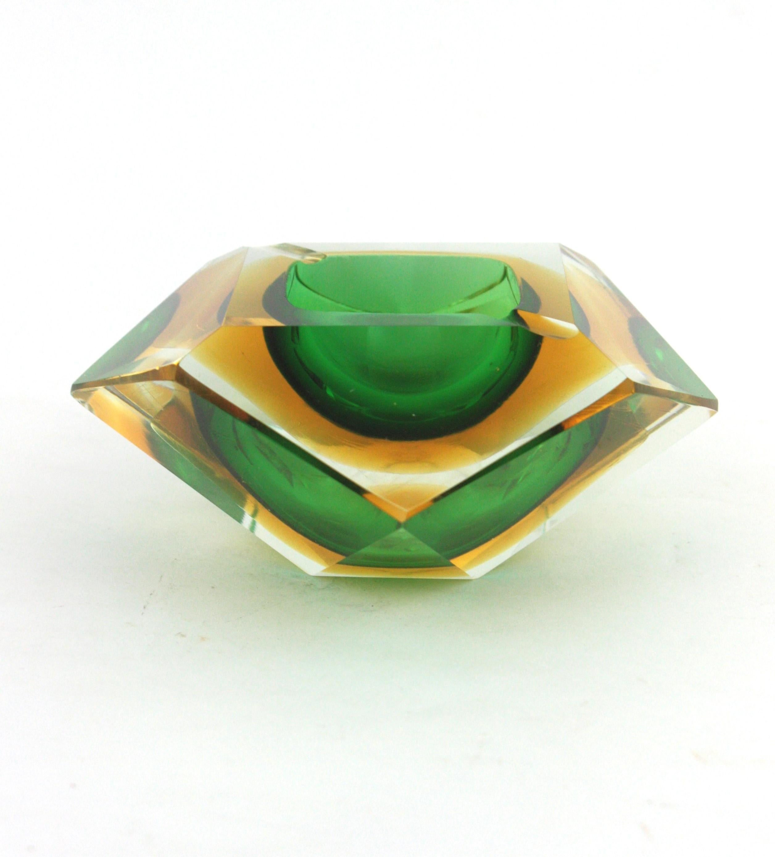 Eye-catching Sommerso faceted Murano glass bowl or ashtray in green and yellow double cased glass in clear class. Faceted diamond shape and vibrant colors. Attributed to Flavio Poli for Seguso Vetri d'Arte.
It can be used as jewelry bowl, candy