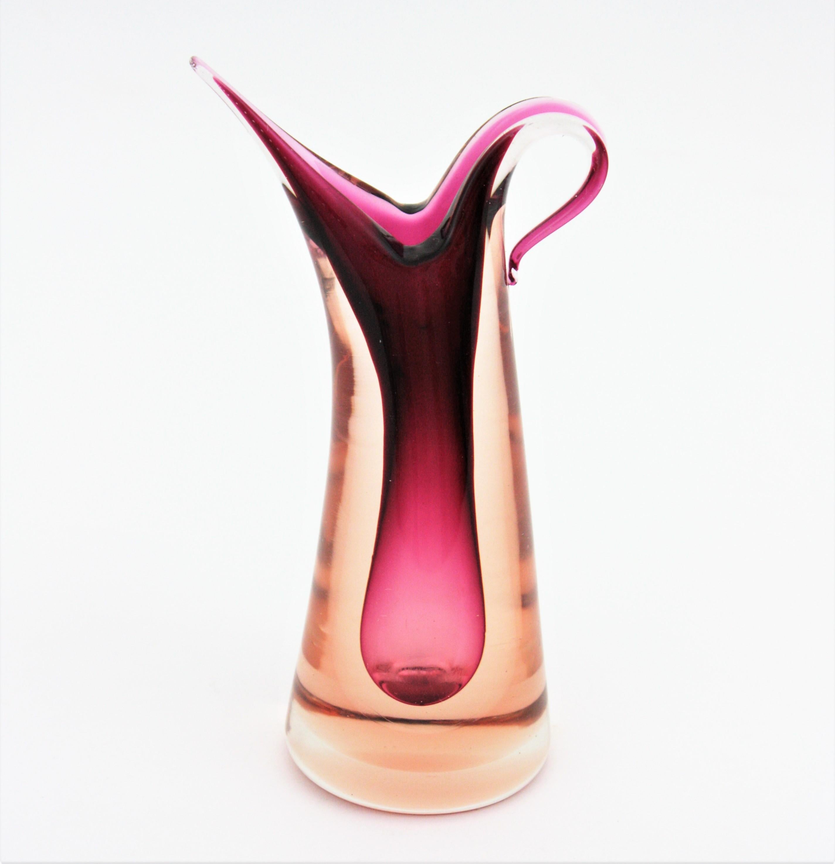 Sommerso Murano Jug Shaped Vase in shades of Pink and Garnet. Designed by Flavio Poli and manufactured by Seguso Vetri d'Arte. Italy, 1950s.
Amazing jug shape and eye-catching colors.
Lovely to be used as flower vase or decorative vase. To be